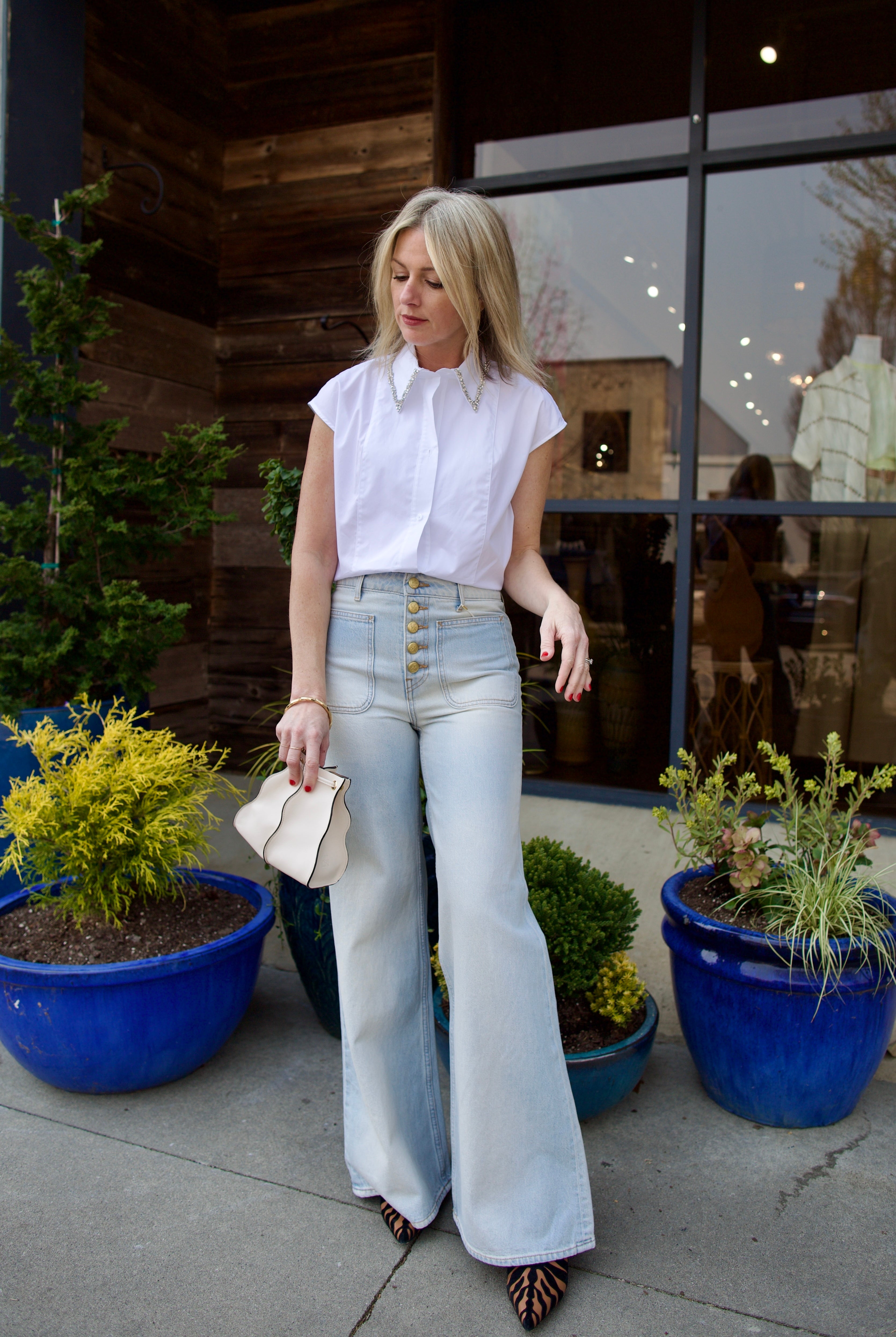 Mature model wearing luxury brand TWP white cap sleeve top with detachable crystal beaded collar in premium cotton