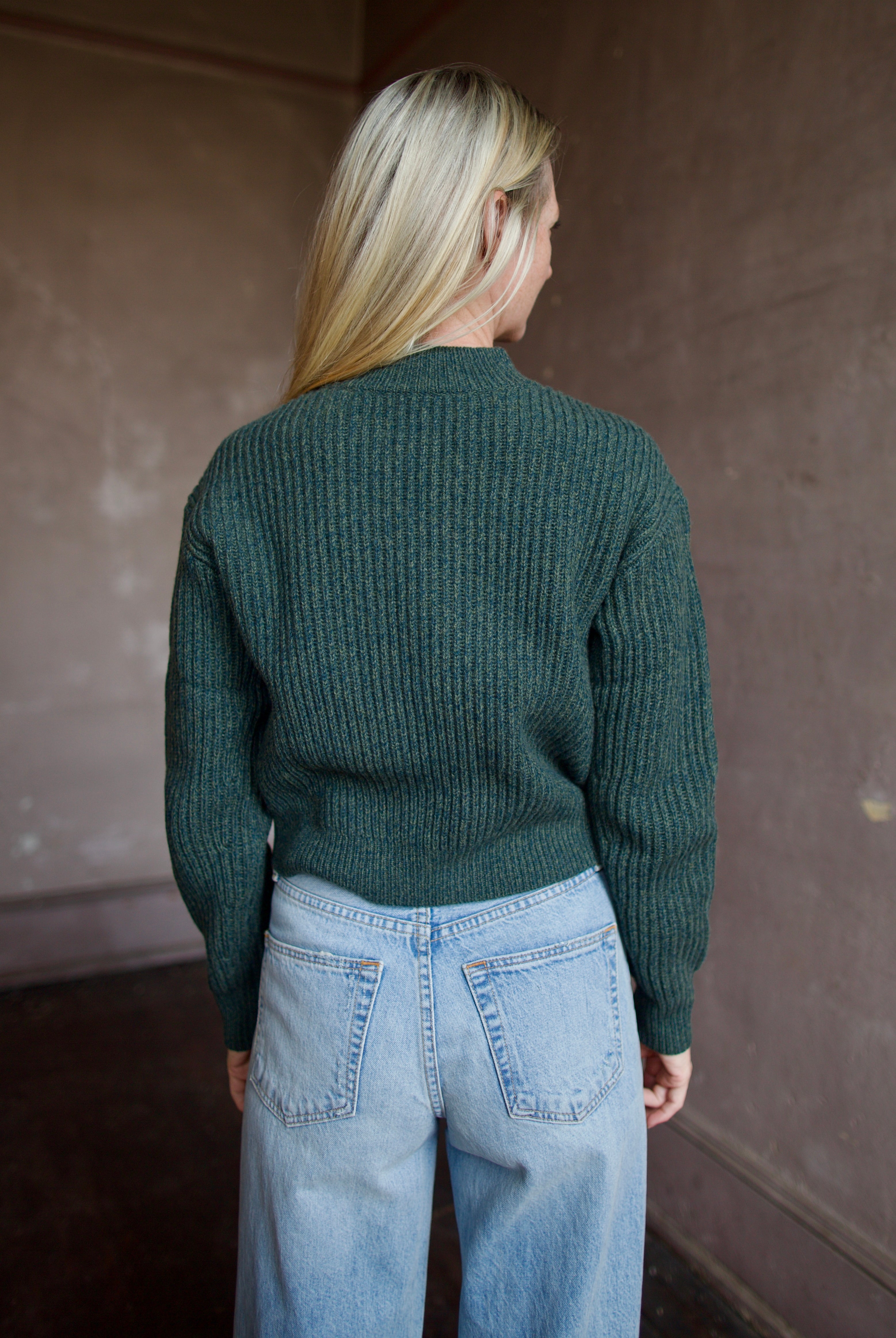 Mature wearing a green button front v neck cashmere cardigan by luxury New York brand TWP