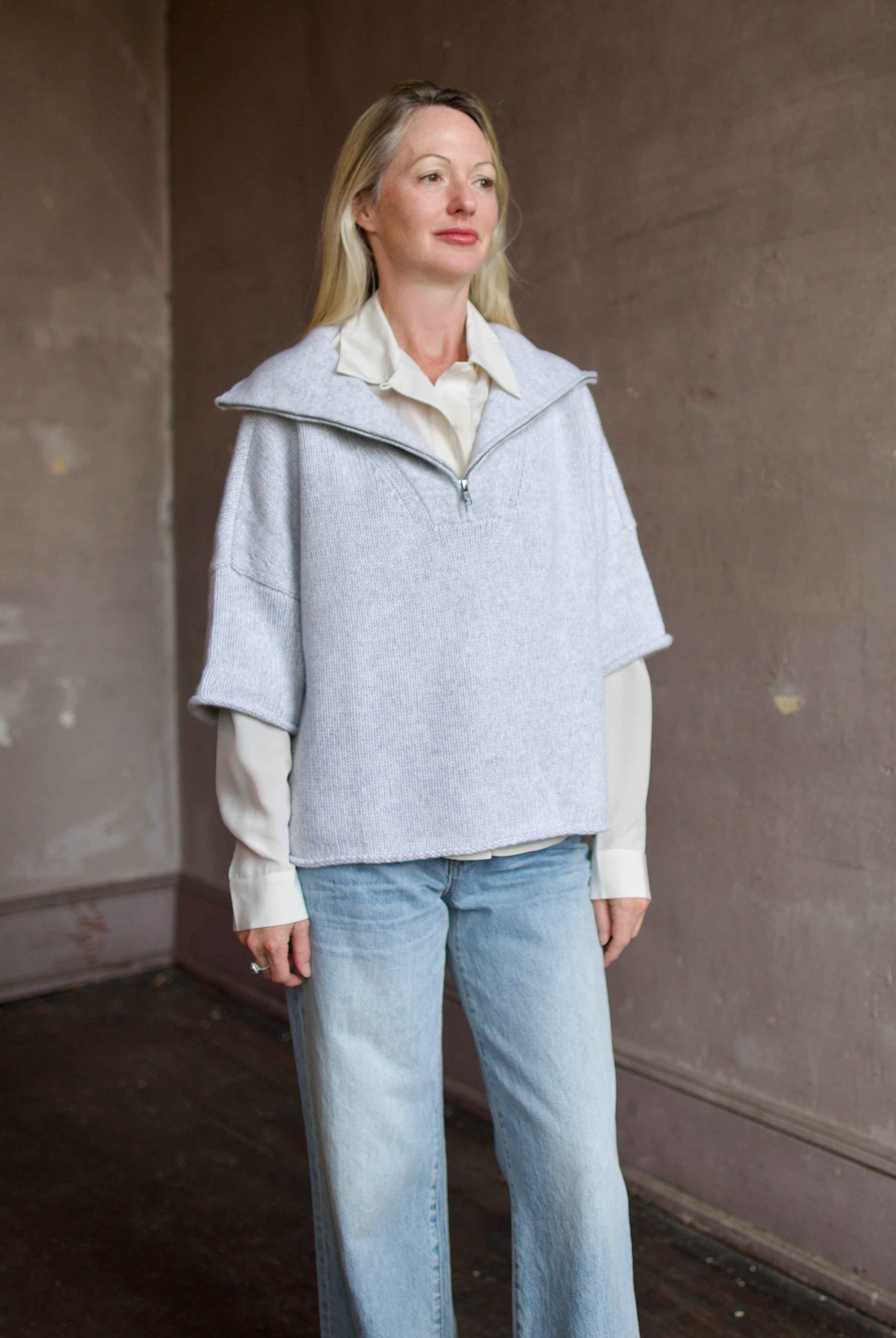 Mature model wearing a light gray layering cashmere sweater with 3/4 zip by American designer TWP