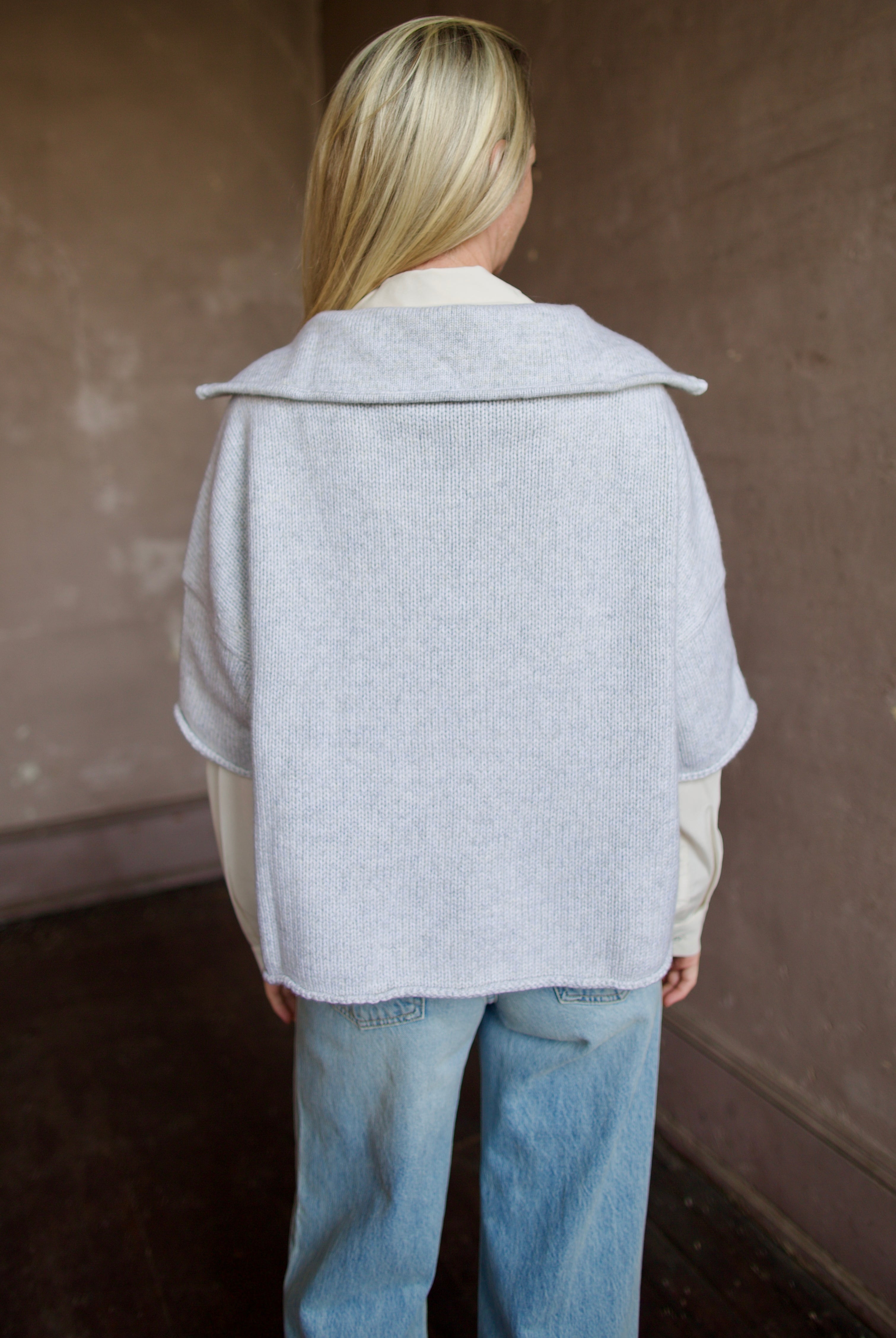 Mature model wearing a light gray layering cashmere sweater with 3/4 zip by American designer TWP