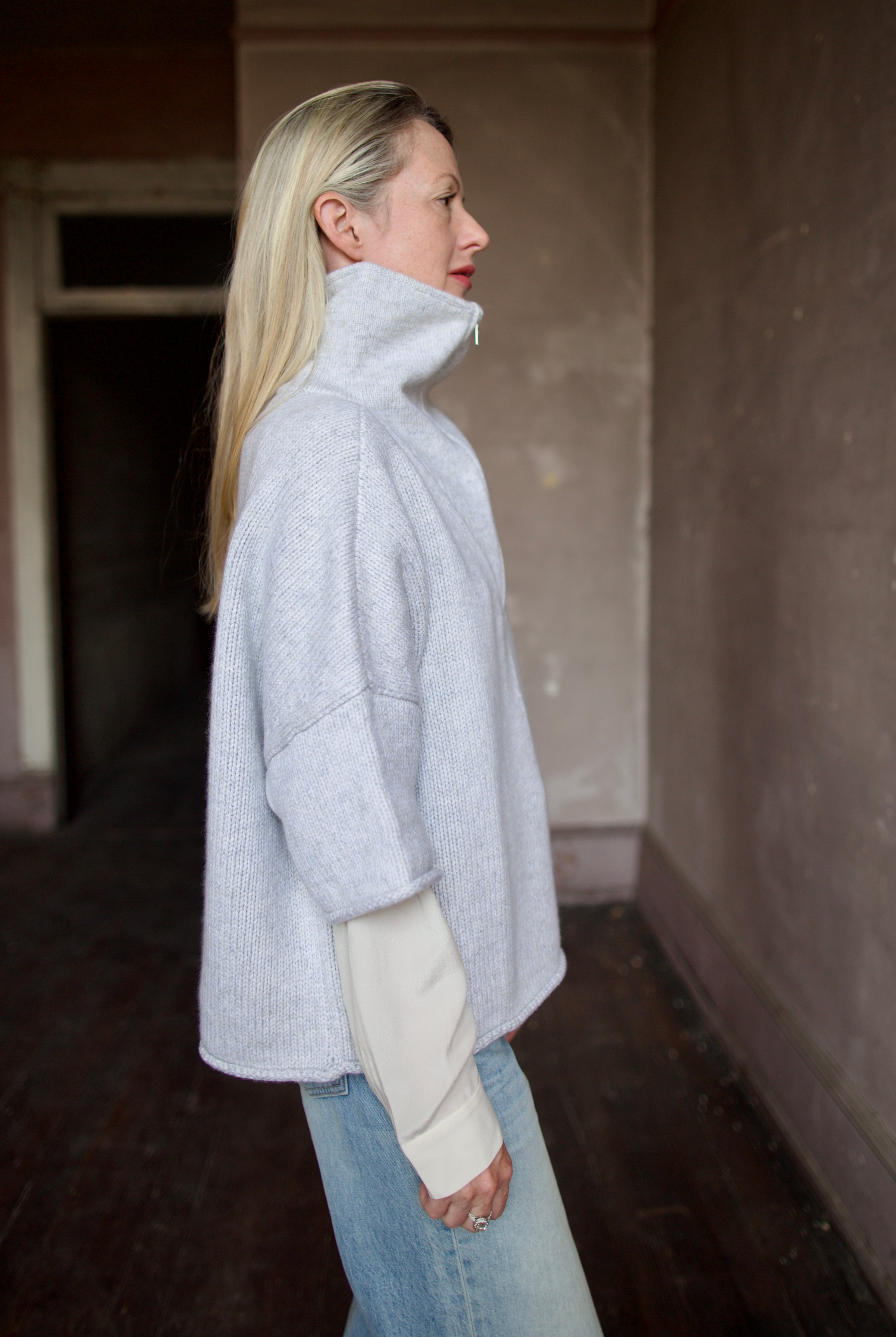 Mature model wearing a light gray layering cashmere sweater with 3/4 zip by American designer TWP
