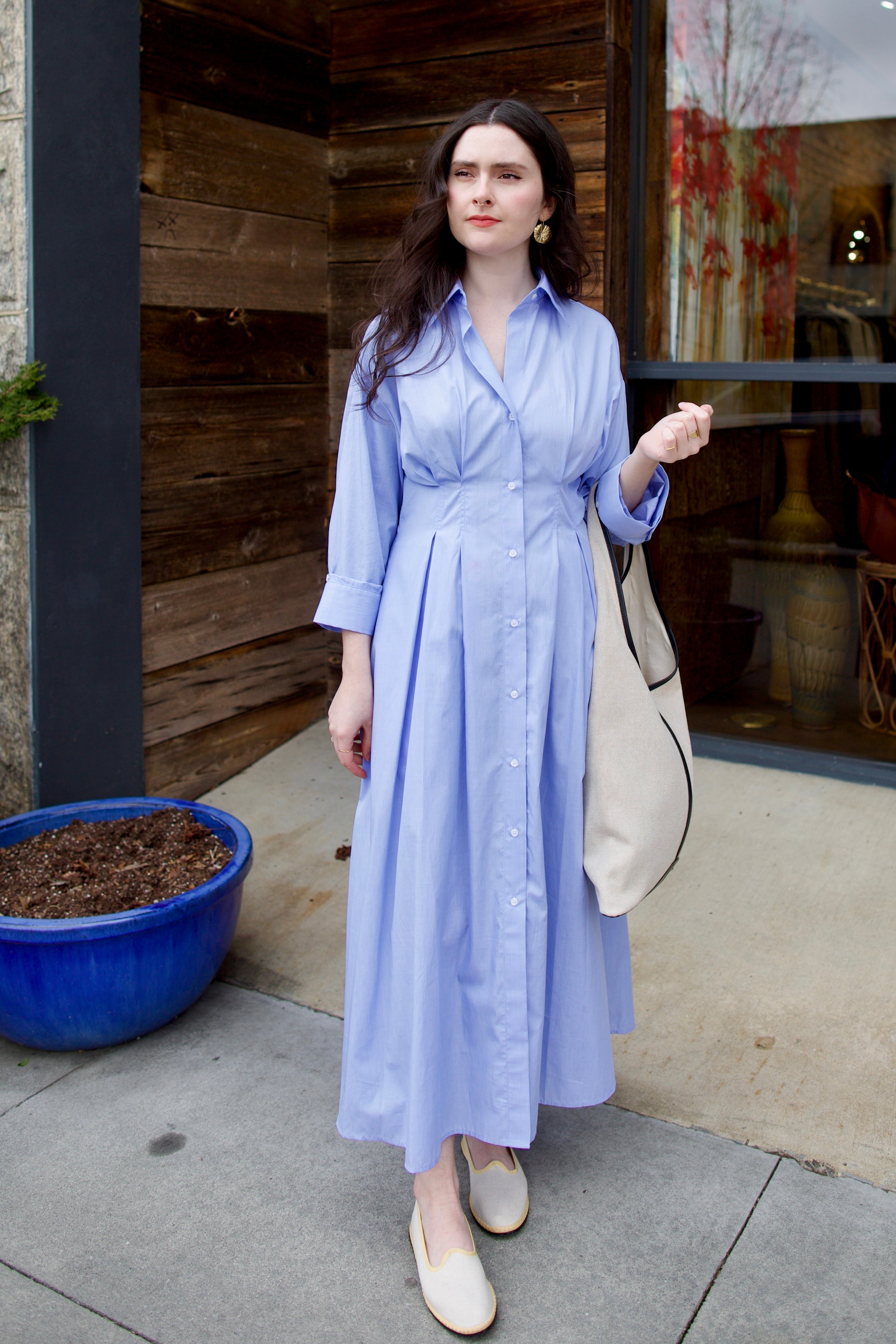 Image of woman wearing TWP M Dress, luxury women's superfine cotton dress featuring button-front closure with pleats and midi hem in blue