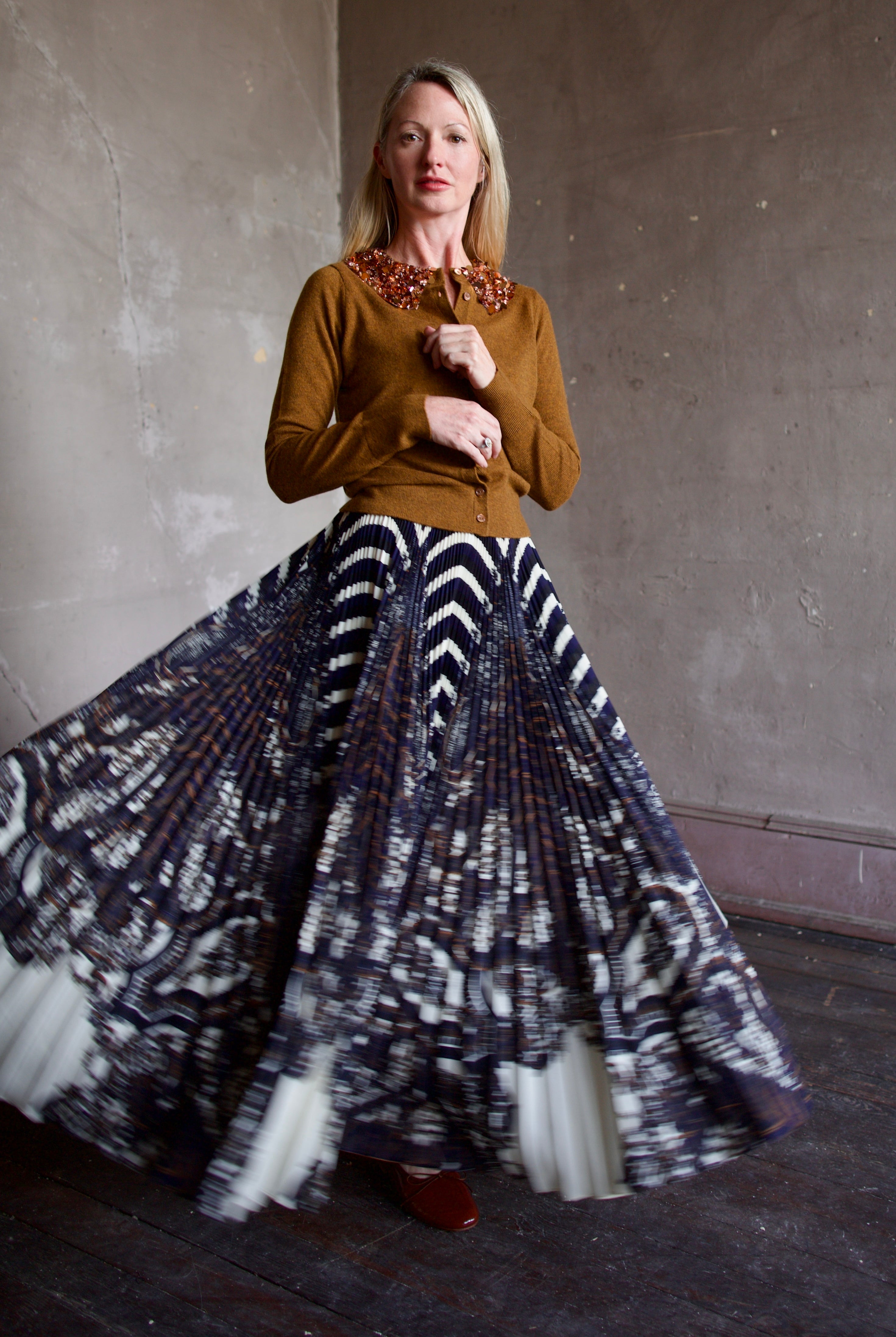 Mature model wearing a brown cashmere cardigan with a sequin embellished collar by Ulla Johnson