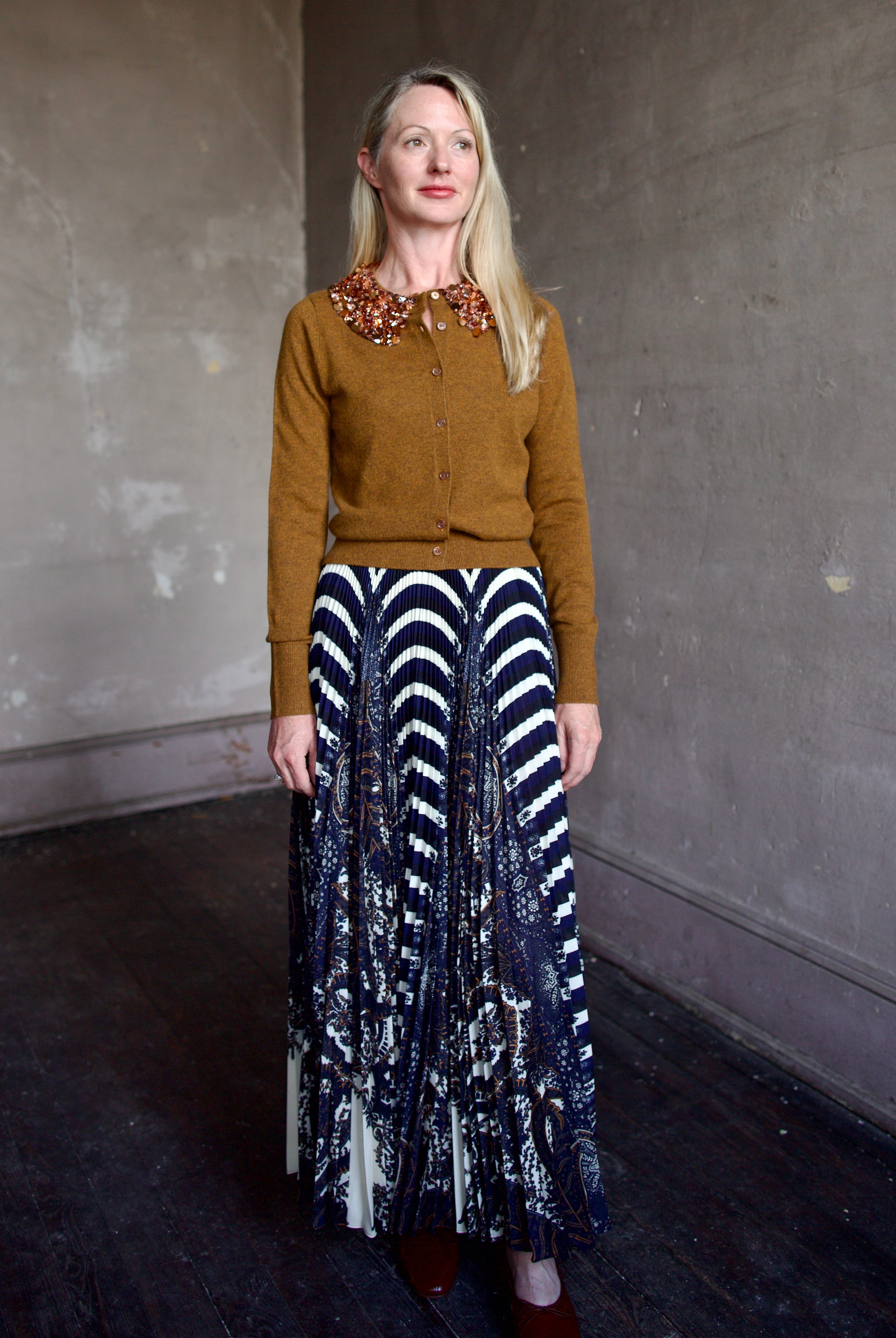 Mature model wearing a brown cashmere cardigan with a sequin embellished collar by Ulla Johnson