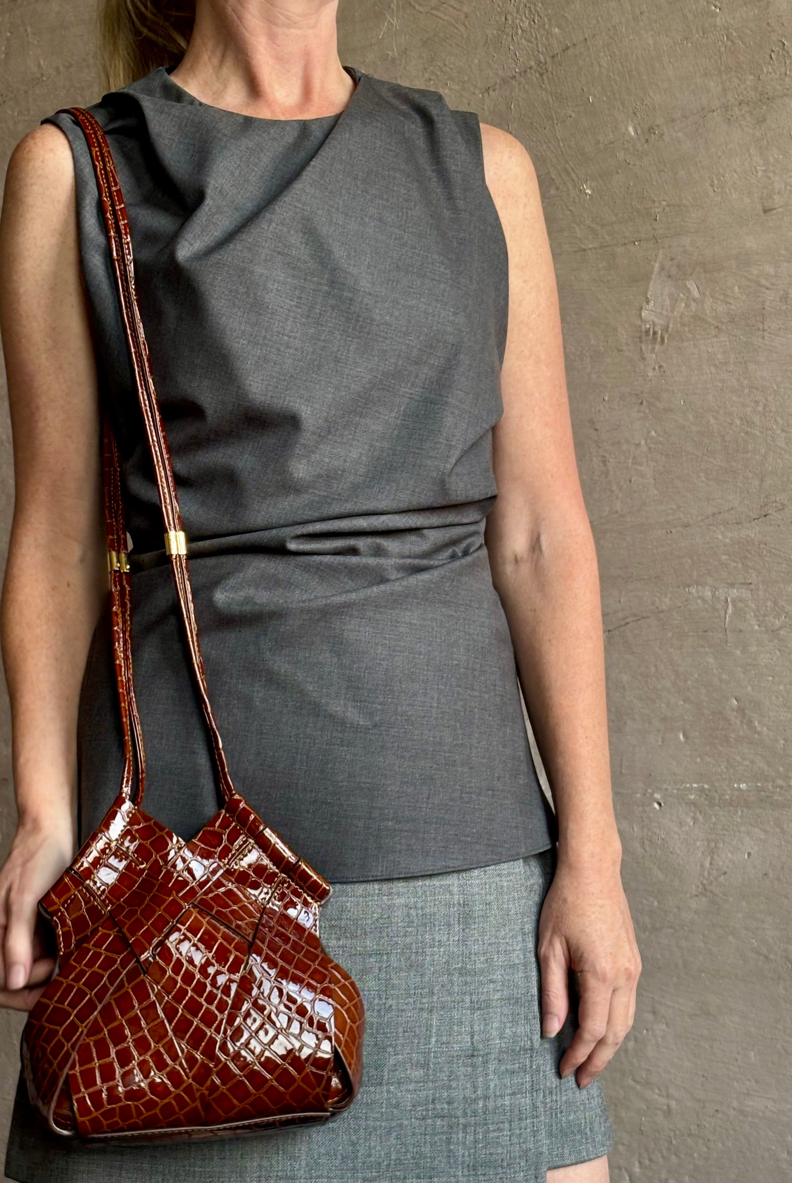 Image of mature model wearing luxury designer ULLA JOHNSON Charlotte Crossbody handbag in Chestnut brown with Crocodile-Embossed leather