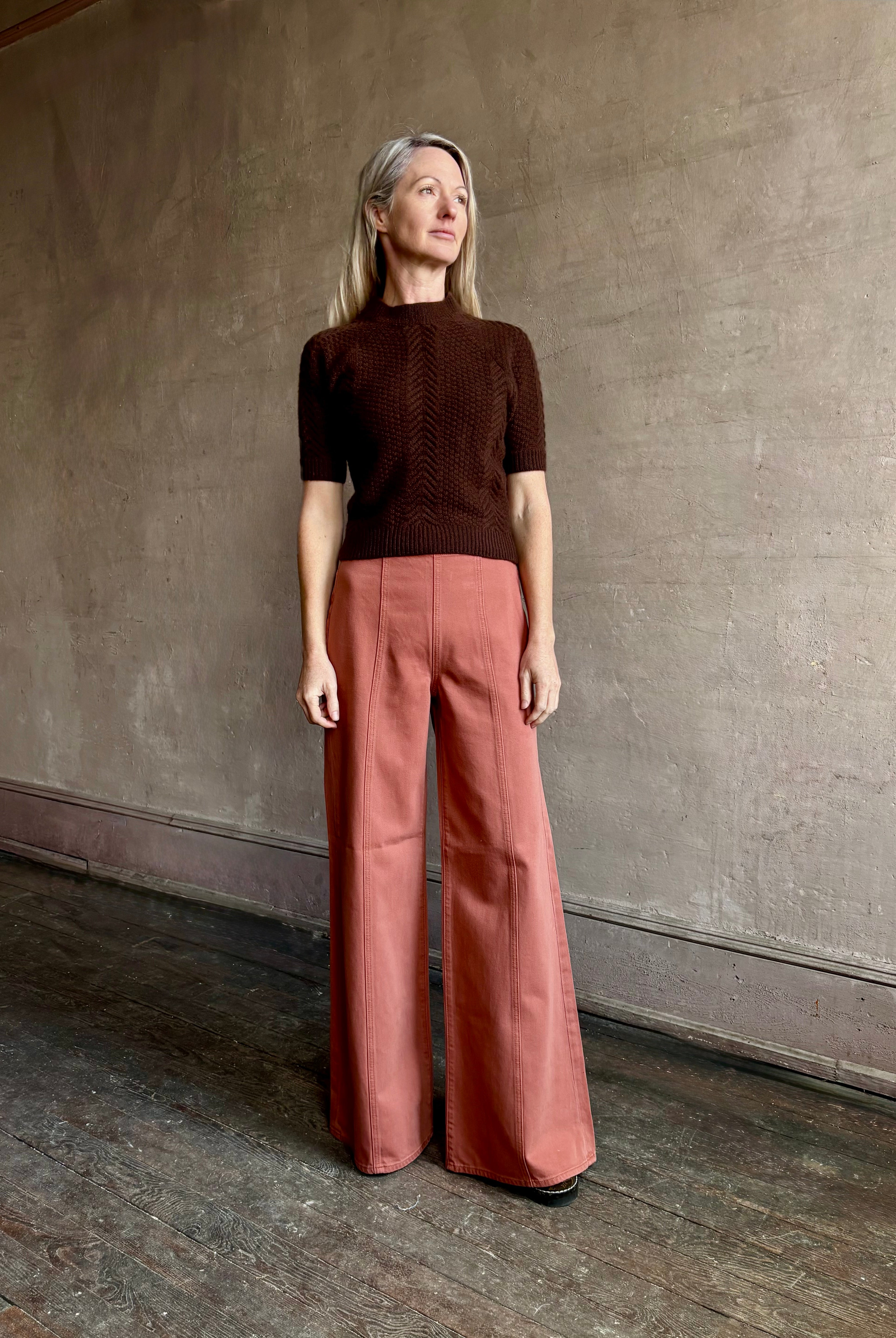 Woman wearing ULLA JOHNSON Bianca faded red rigid Jean with flat front and front seam details down leg panels