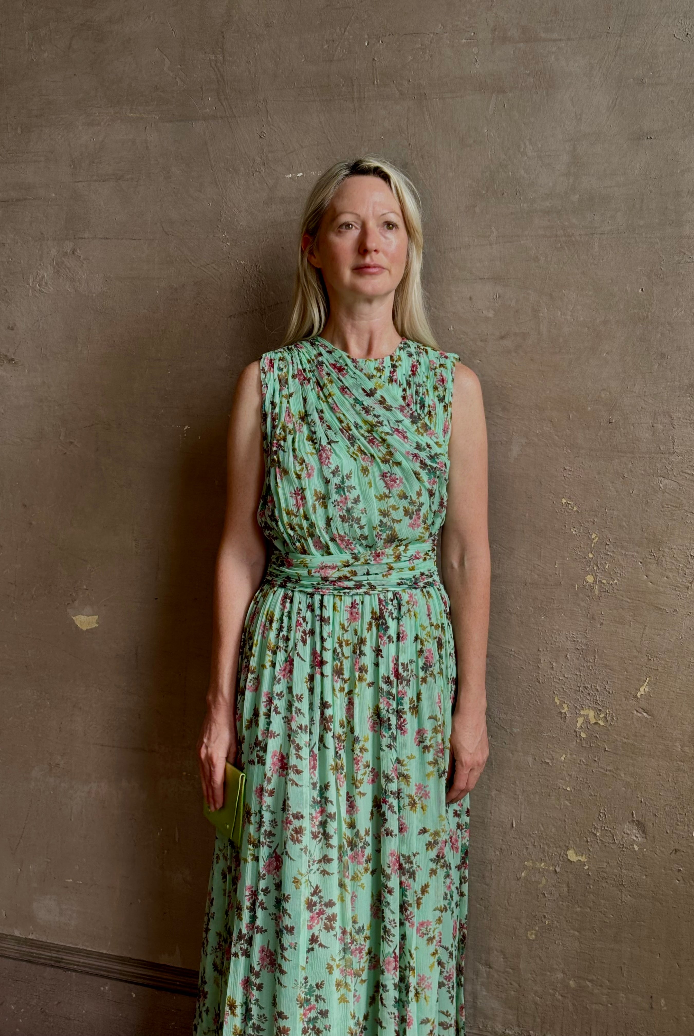 Mature woman wearing women's designer celestina silk maxi dress rendered in a mint green ground adorned with delicate brown and pink florals from Ulla Johnson that is sleevesless with gathered fabric bodice and waistband