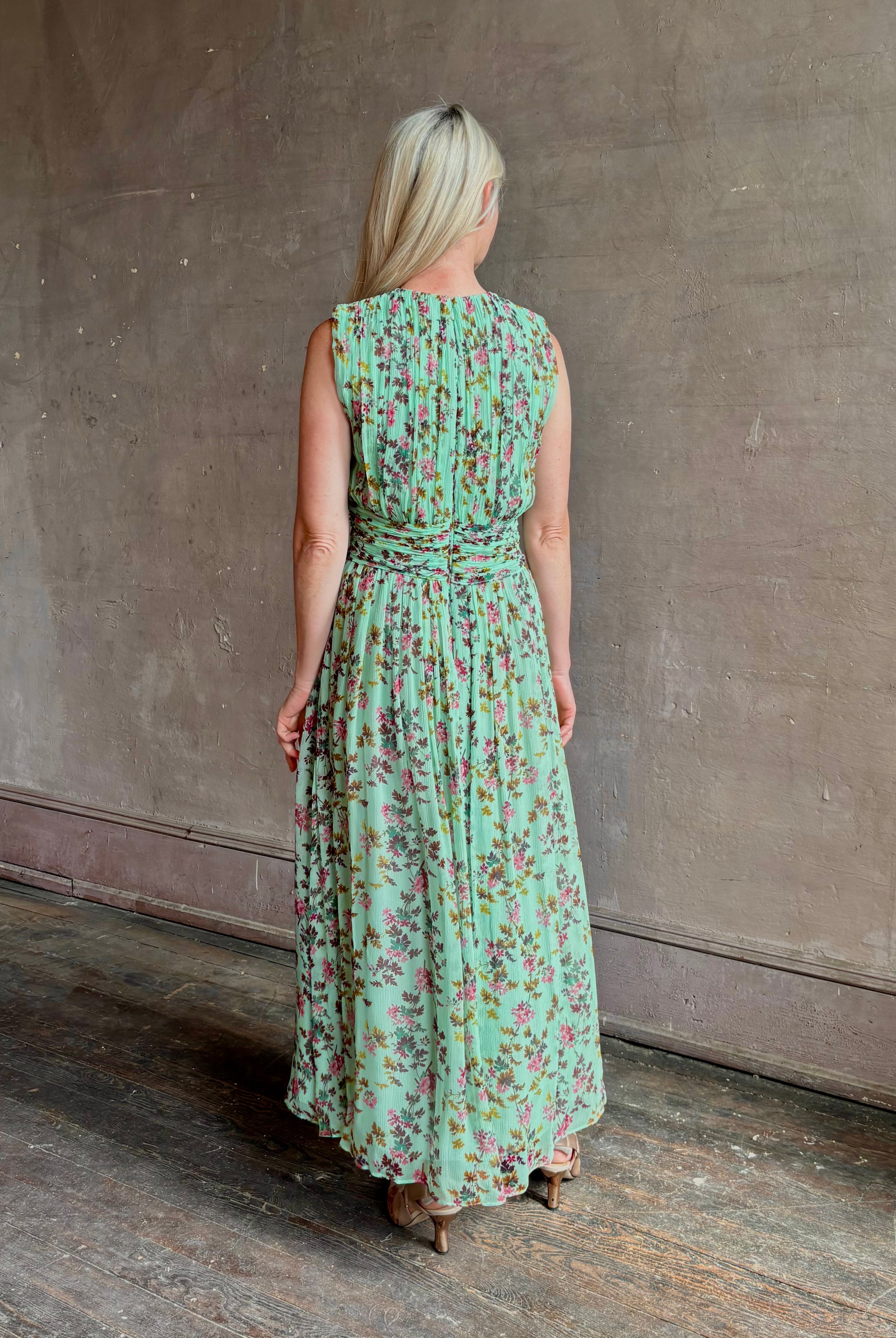 Mature woman wearing women's designer celestina silk maxi dress rendered in a mint green ground adorned with delicate brown and pink florals from Ulla Johnson that is sleevesless with gathered fabric bodice and waistband