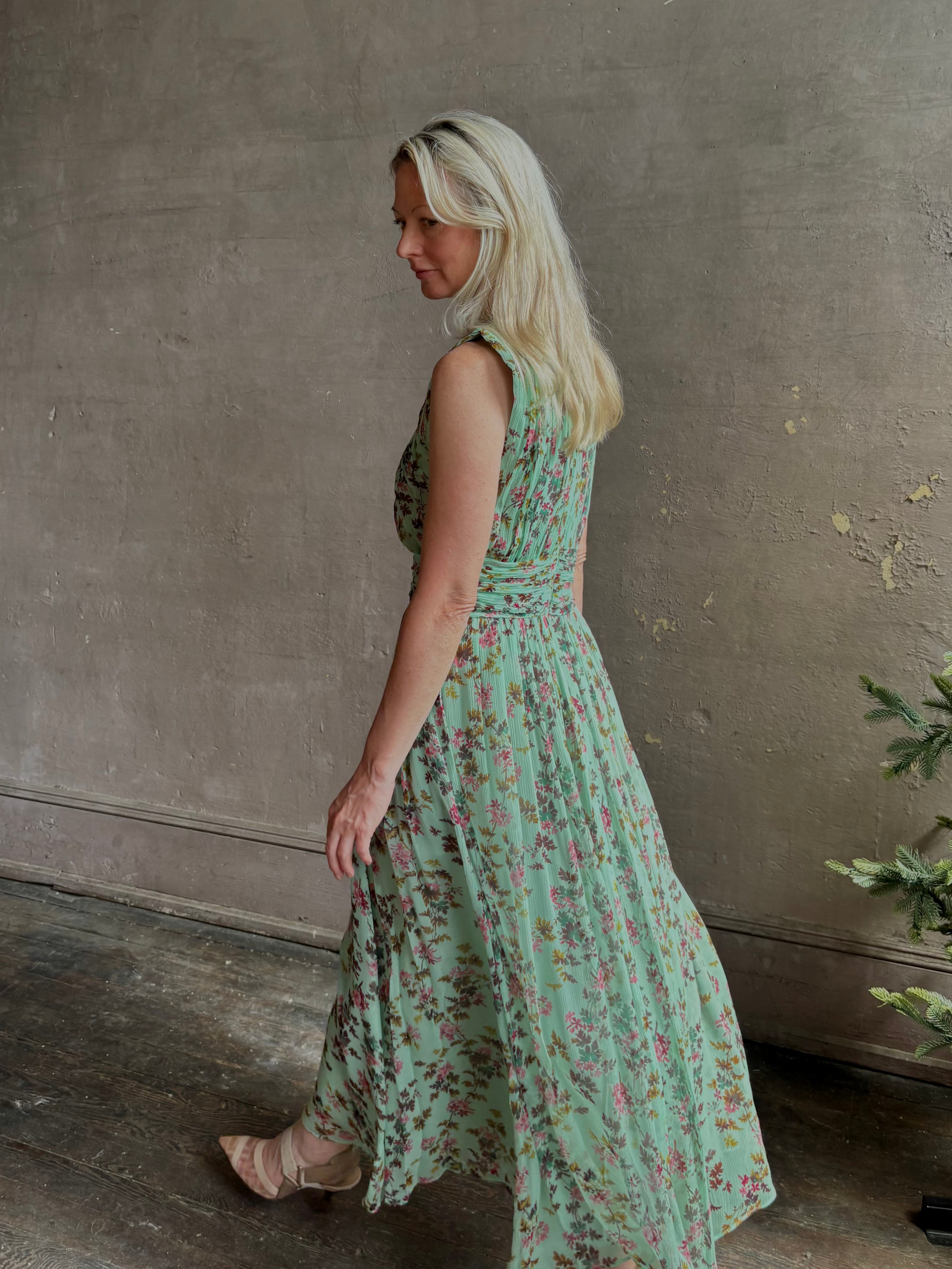 Mature woman wearing women's designer celestina silk maxi dress rendered in a mint green ground adorned with delicate brown and pink florals from Ulla Johnson that is sleevesless with gathered fabric bodice and waistband