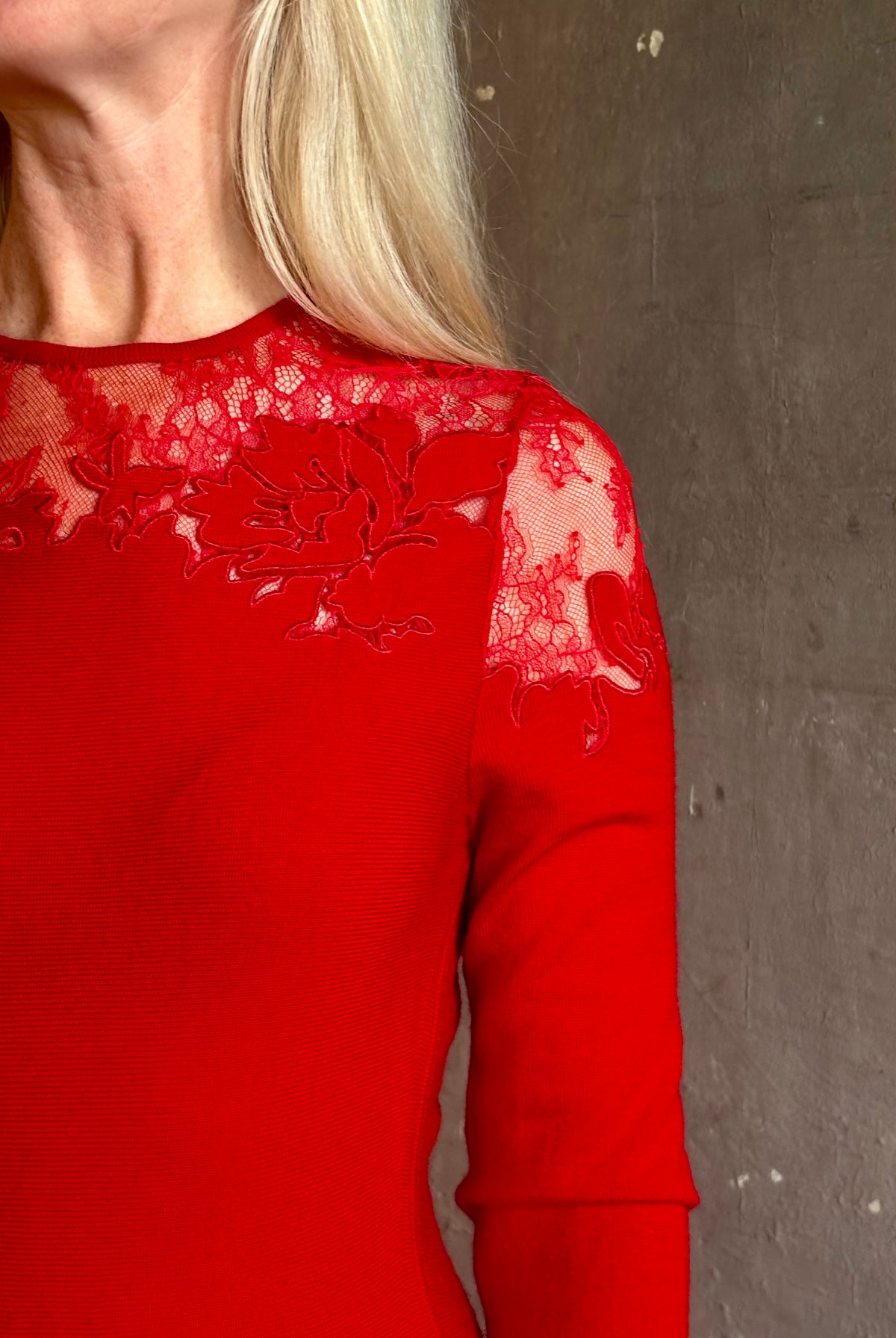 Mature woman wearing designer Ulla Johnson's Clemence LS Lace Dress in Cerise red virgin wool knit with delicate lace at the bodice and hemline striking sophisticated occasion elegance