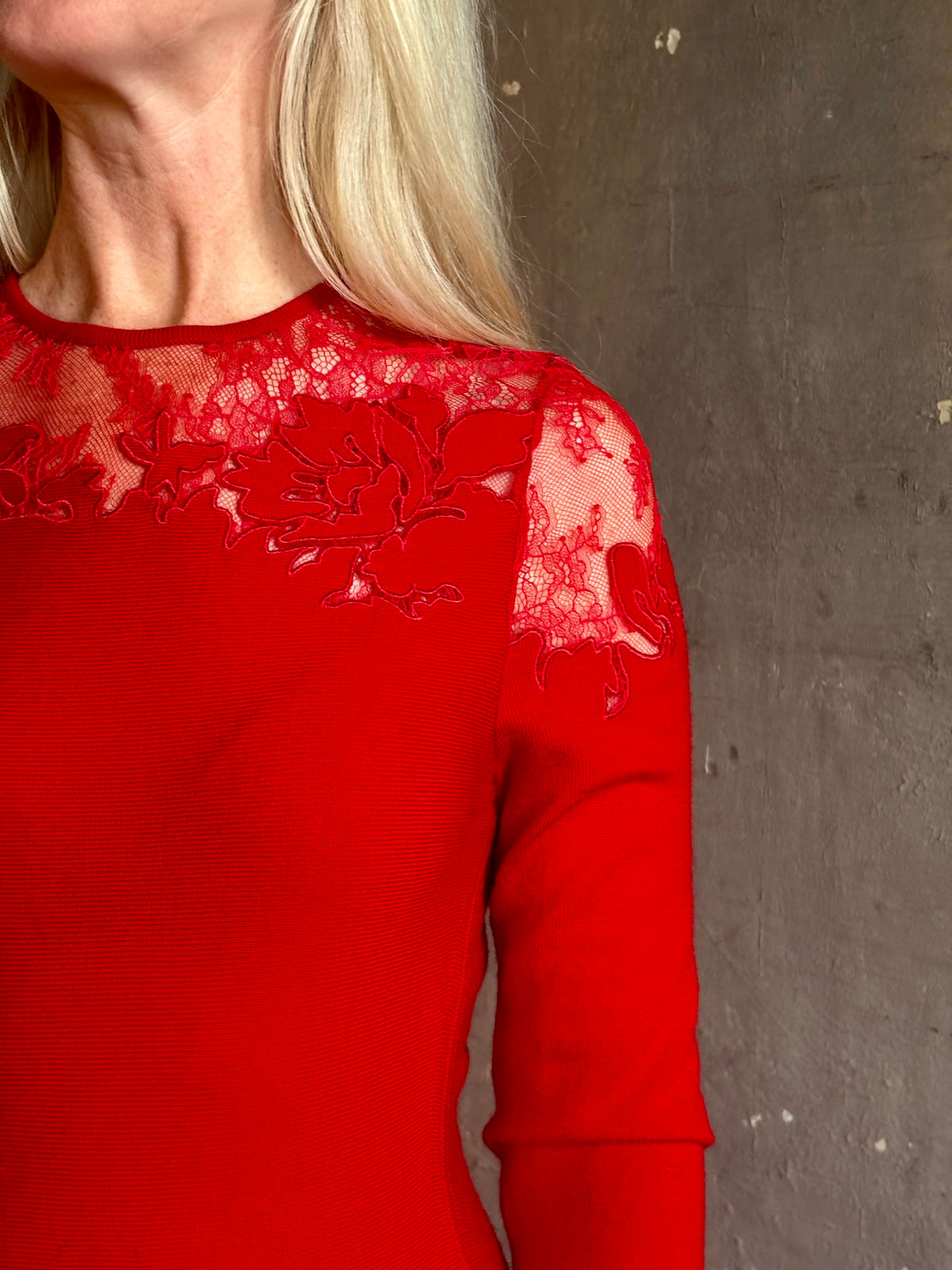 Mature woman wearing designer Ulla Johnson's Clemence LS Lace Dress in Cerise red virgin wool knit with delicate lace at the bodice and hemline striking sophisticated occasion elegance