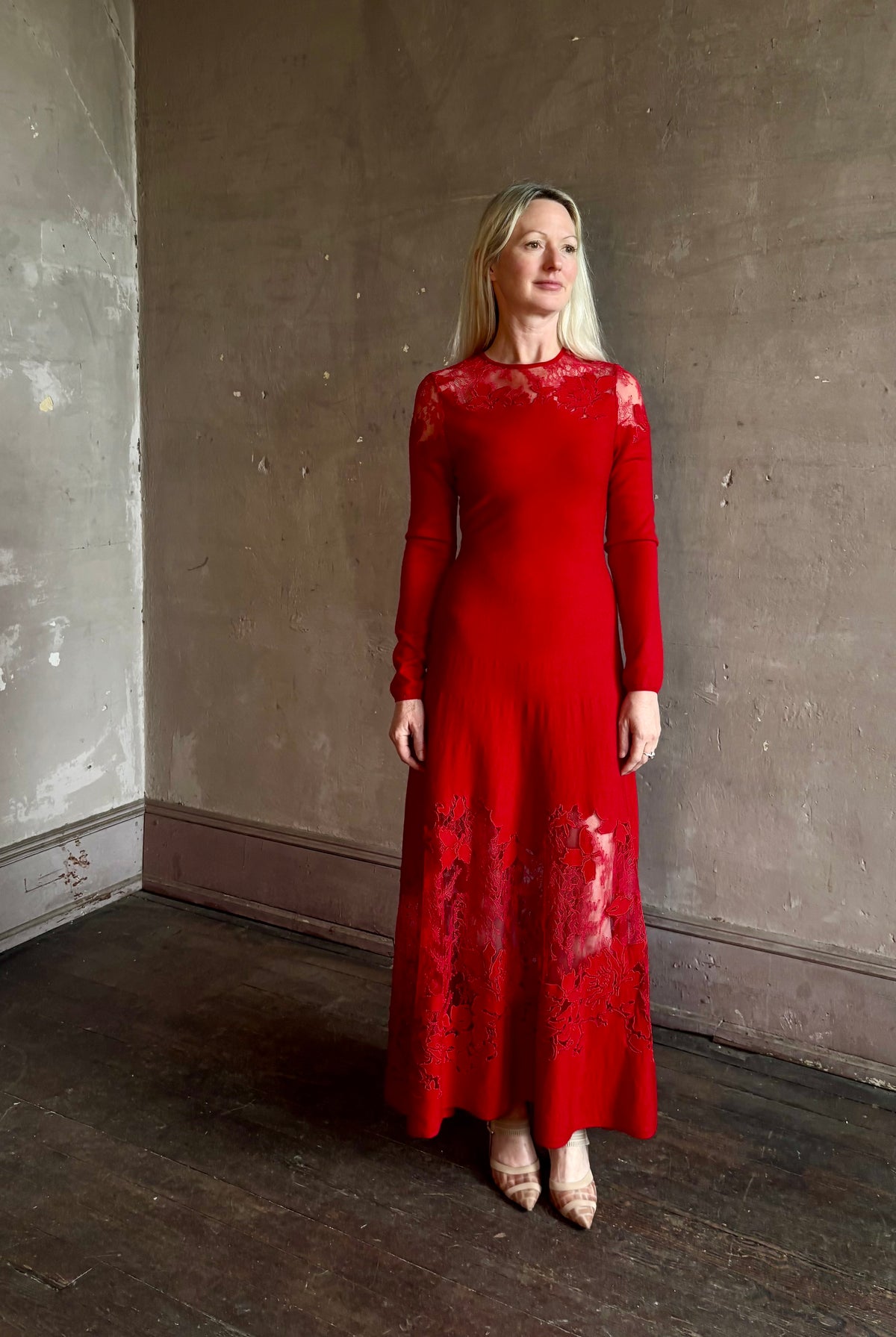 Mature woman wearing designer Ulla Johnson's Clemence LS Lace maxi Dress in Cerise red virgin wool knit A-line delicate lace at the bodice and hemline striking sophisticated occasion elegance
