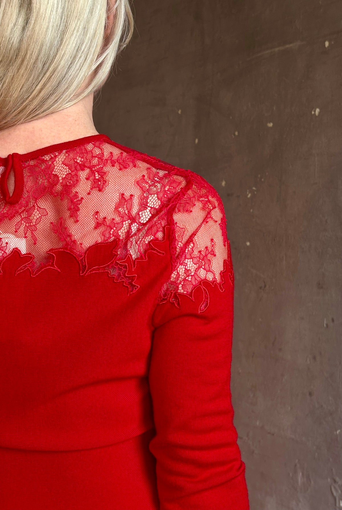Mature woman wearing designer Ulla Johnson's Clemence Long sleeve Lace Dress in Cerise red virgin wool knit with delicate lace at the bodice