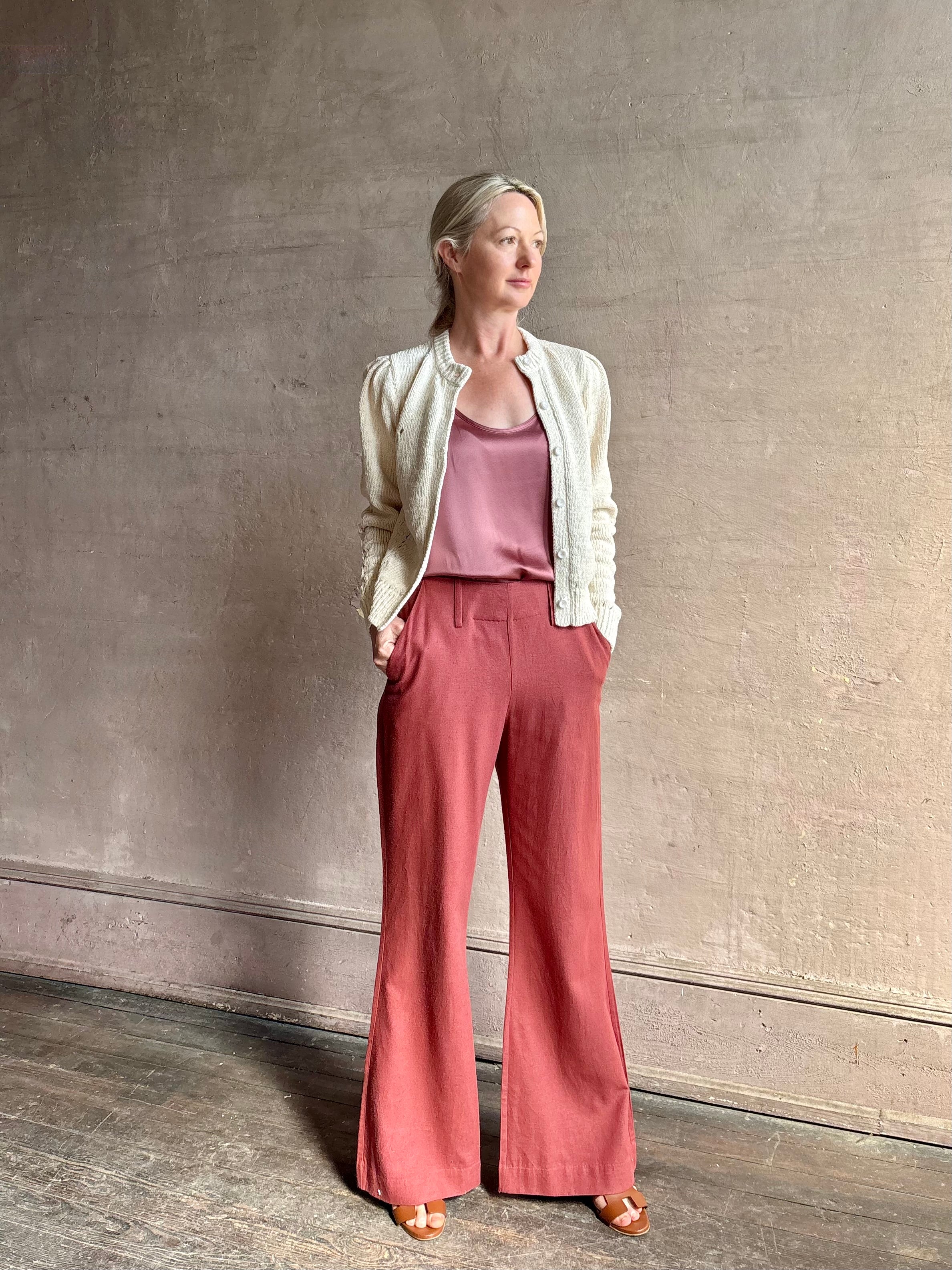 Mature woman wearing the Delphina Long Sleeve Cardigan from Ulla Johnson rendered in a soft off-white with crew neck, feminine sleeves and button front