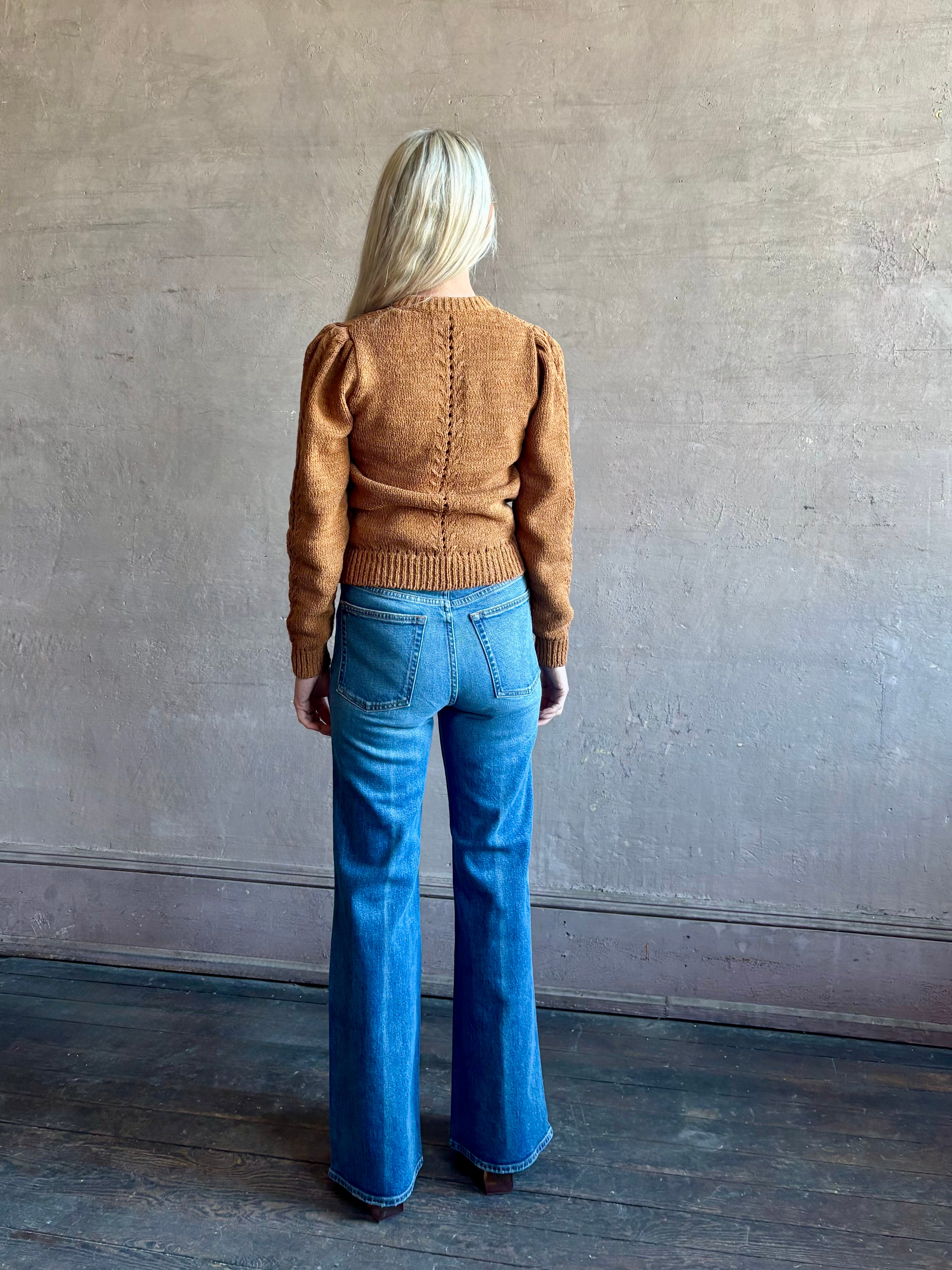 Mature woman wearing the Delphina Long Sleeve women's designer Cardigan from Ulla Johnson rendered in an umber hue with a crew neck and button front