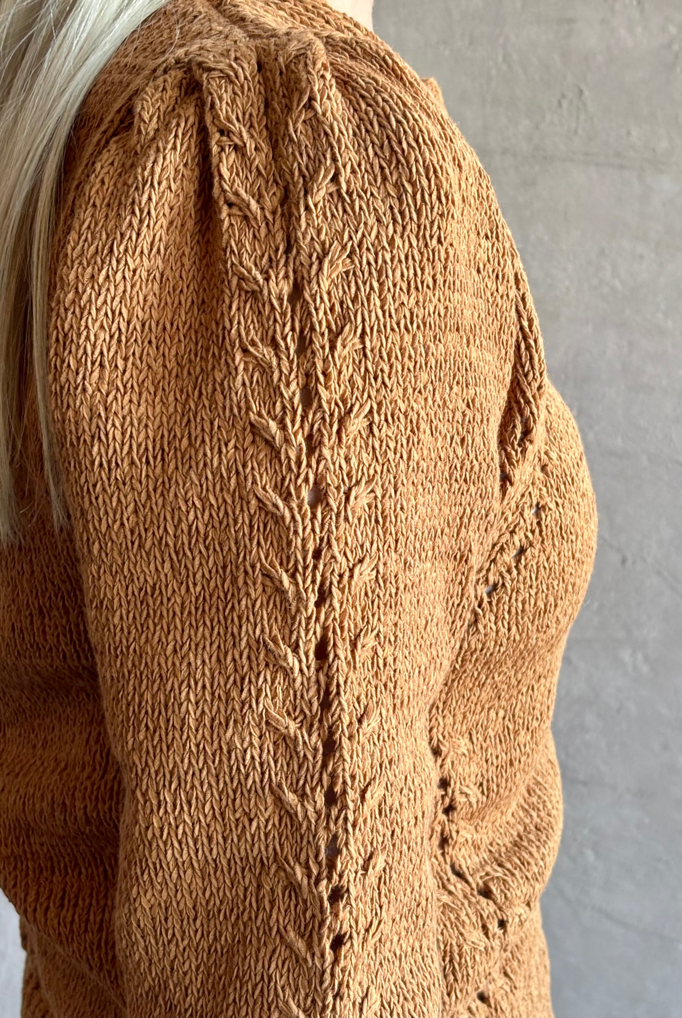 Mature woman wearing the Delphina Long Sleeve women's designer Cardigan from Ulla Johnson rendered in an umber hue with a crew neck and button front