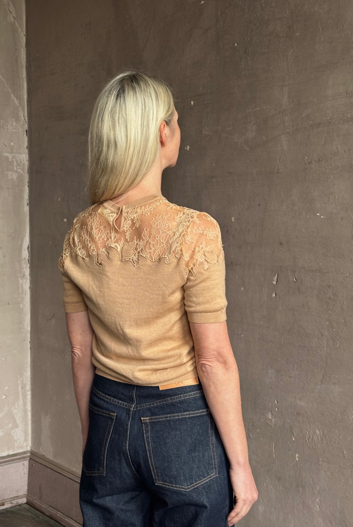 Mature woman wearing Ulla Johnson's Ella Short Sleeve Lace merino wool knit Top in Almond delicate lace detailing at the shoulders timeless elegance