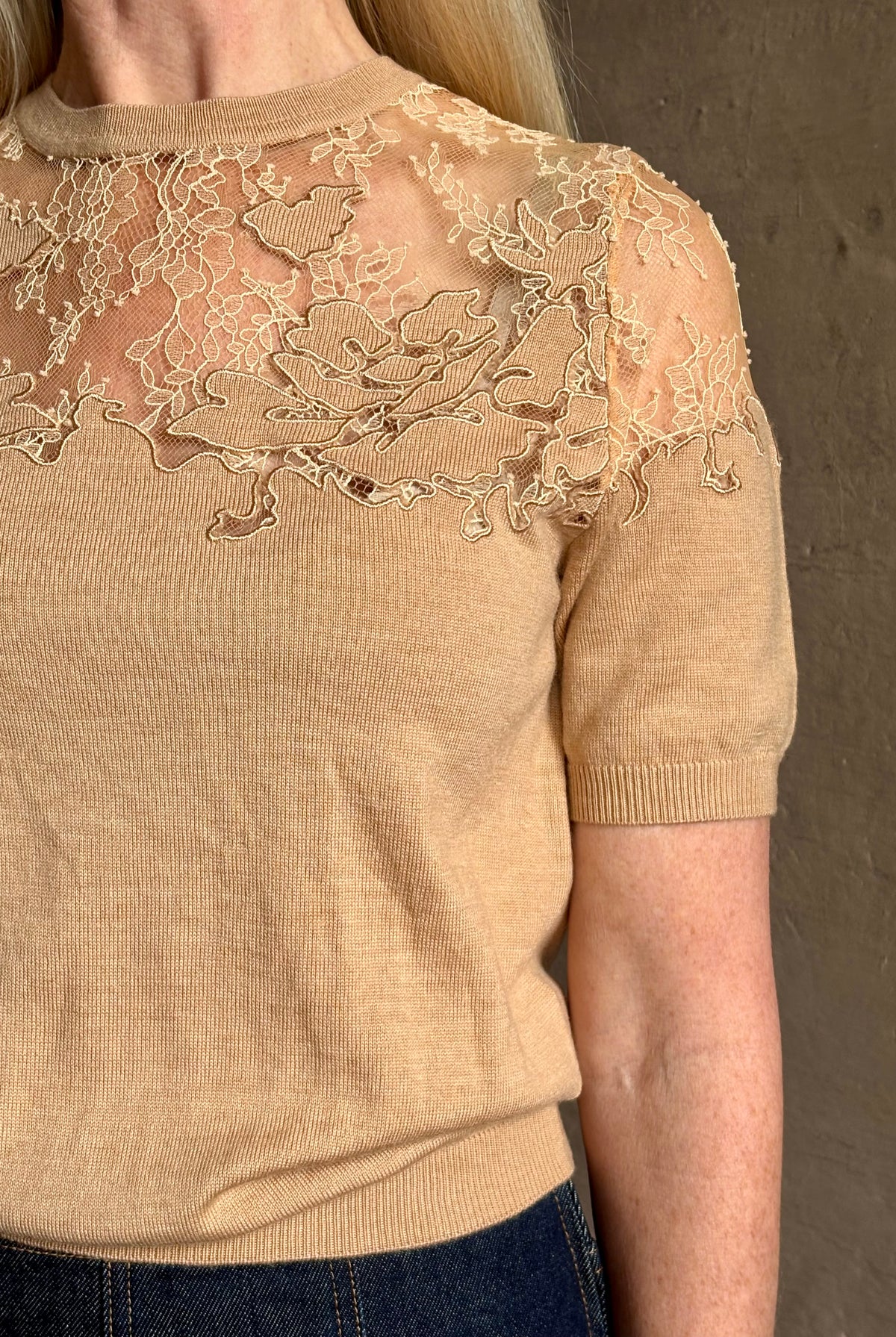 Mature woman wearing Ulla Johnson's Ella Short Sleeve Lace merino wool knit Top in Almond delicate lace detailing at the shoulders classic elegance