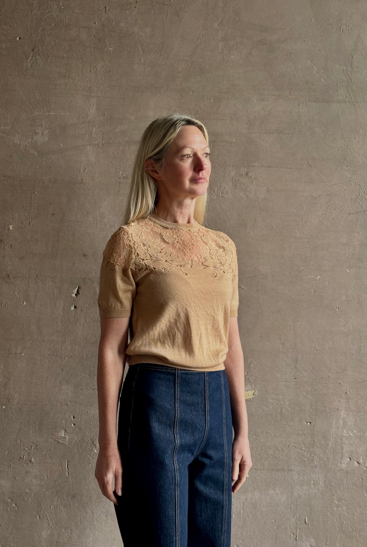 Mature woman wearing Ulla Johnson's Ella Short Sleeve Lace merino wool knit Top in Almond delicate lace detailing at the shoulders Romantic artistic elegance