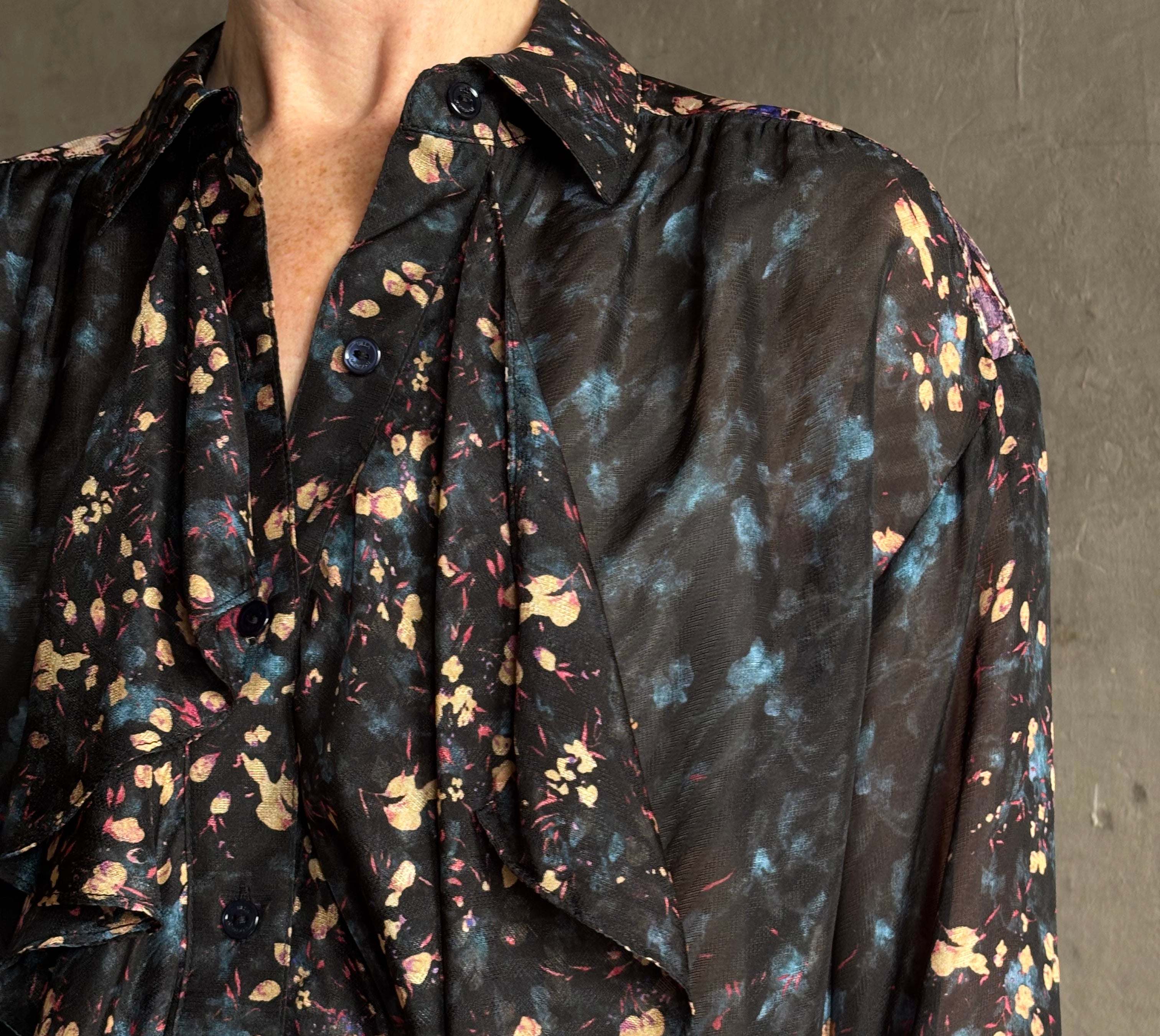 woman wearing designer Ulla Johnson long-sleeve black silk blouse subtle floral print collared button front ruffle