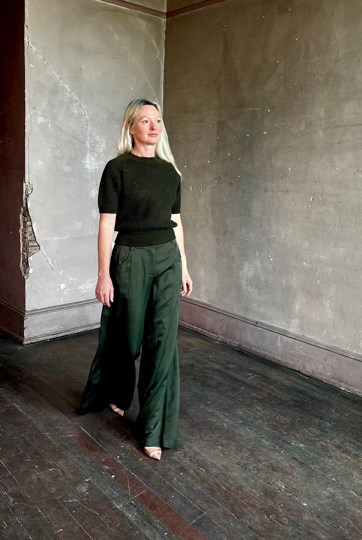 Mature woman wearing designer Ulla Johnson Imara Short Sleeve dark green Sweater with a dimensional open weave