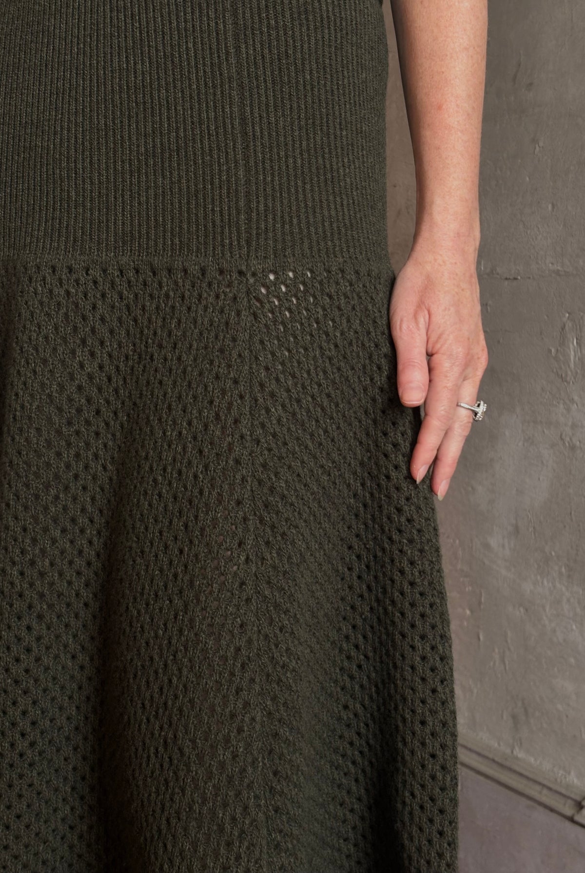 Mature woman wearing designer Ulla Johnson Lucia Wool dark green open Knit maxi Skirt with stretch waistband