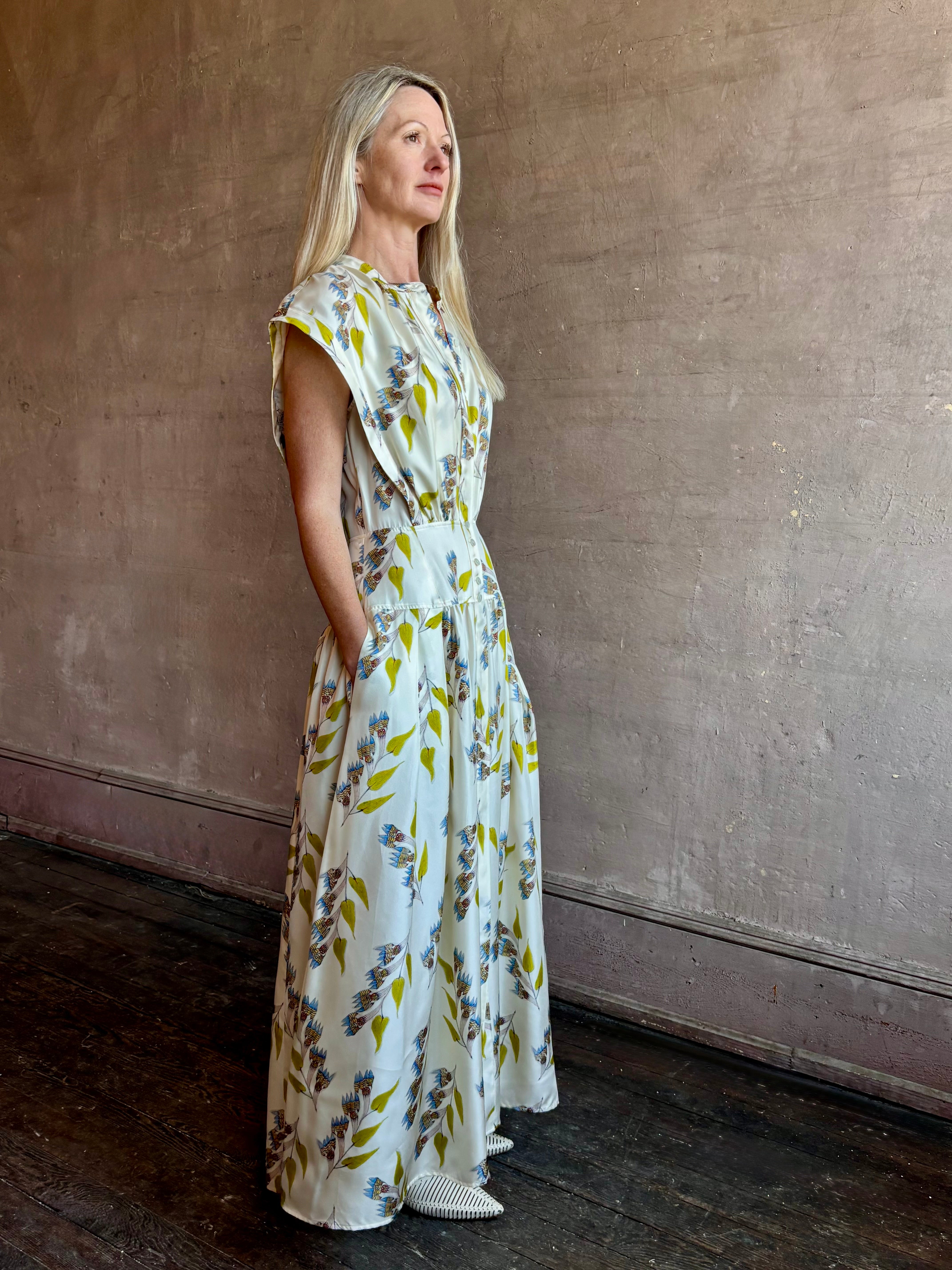 Image of woman wearing limited edition ULLA JOHNSON Lausanne silk occasion dress with pockets in sophisticated floral pattern by painter Anna Zemankova