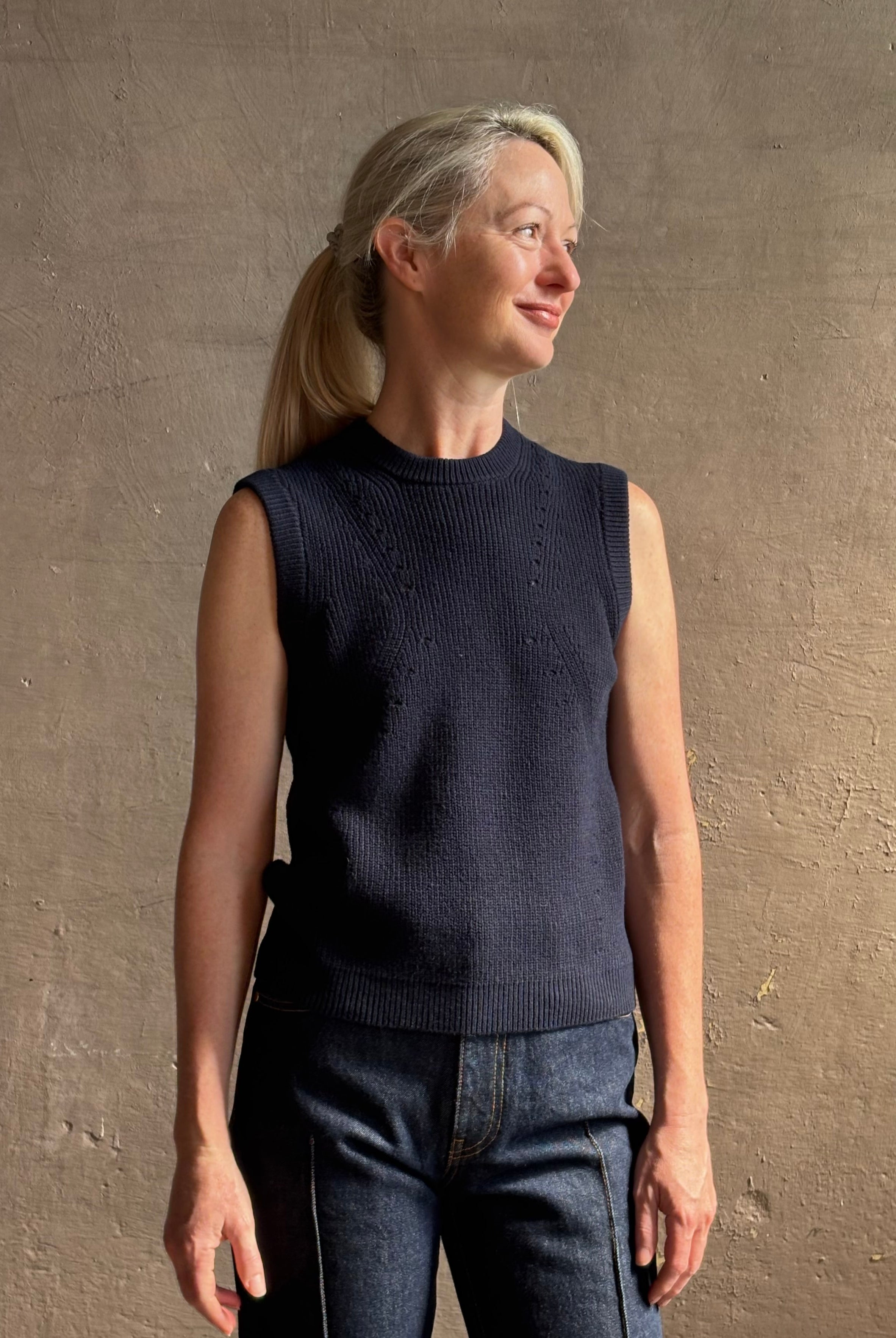 Mature woman wearing designer Margot sleeveless Knit Top from Ulla Johnson rendered in a rich midnight blue and knitted from 100% cotton with refined design details and a crew neckline