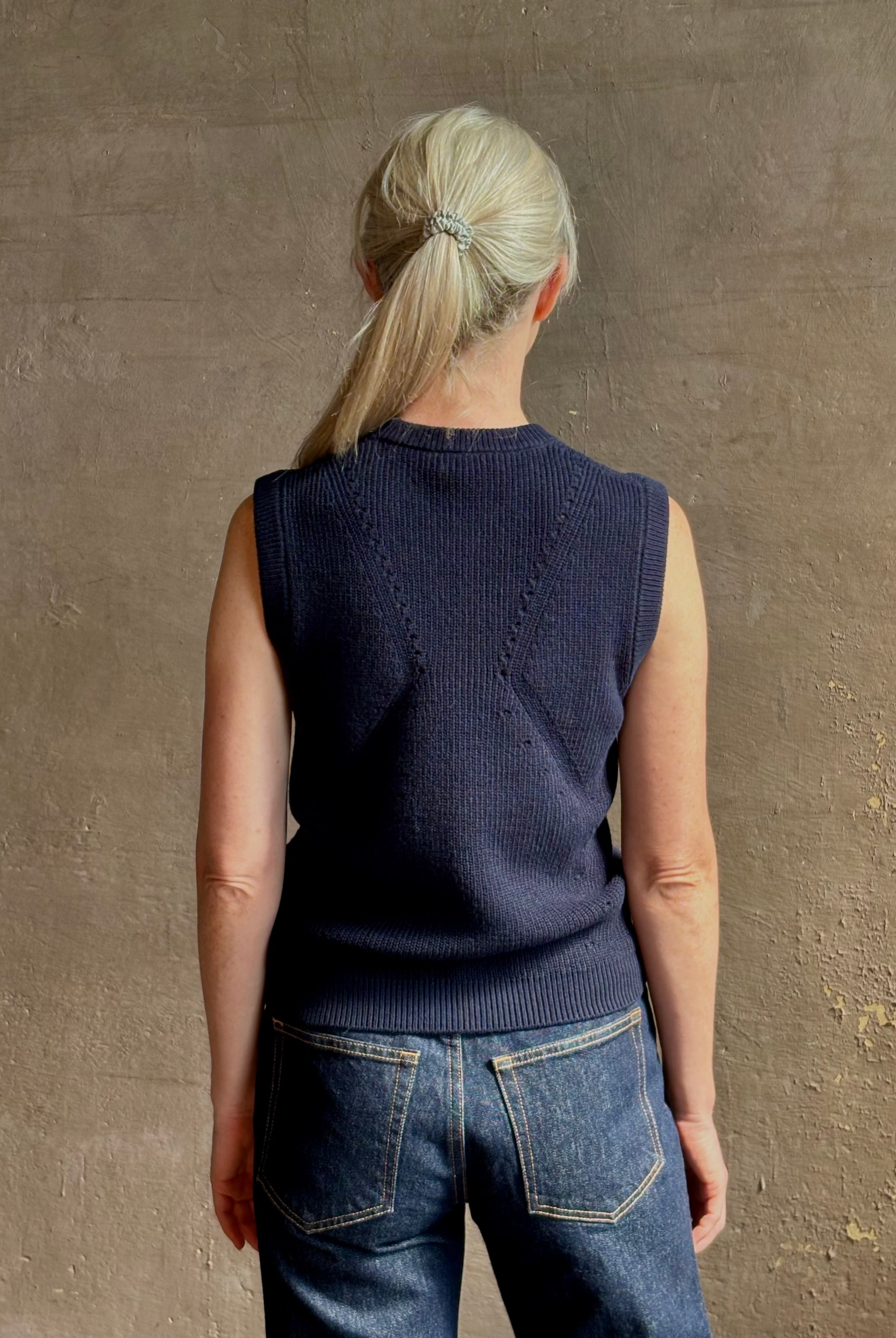 Mature woman wearing designer Margot sleeveless Knit Top from Ulla Johnson rendered in a rich midnight blue and knitted from 100% cotton with refined design details and a crew neckline for everyday sophistication