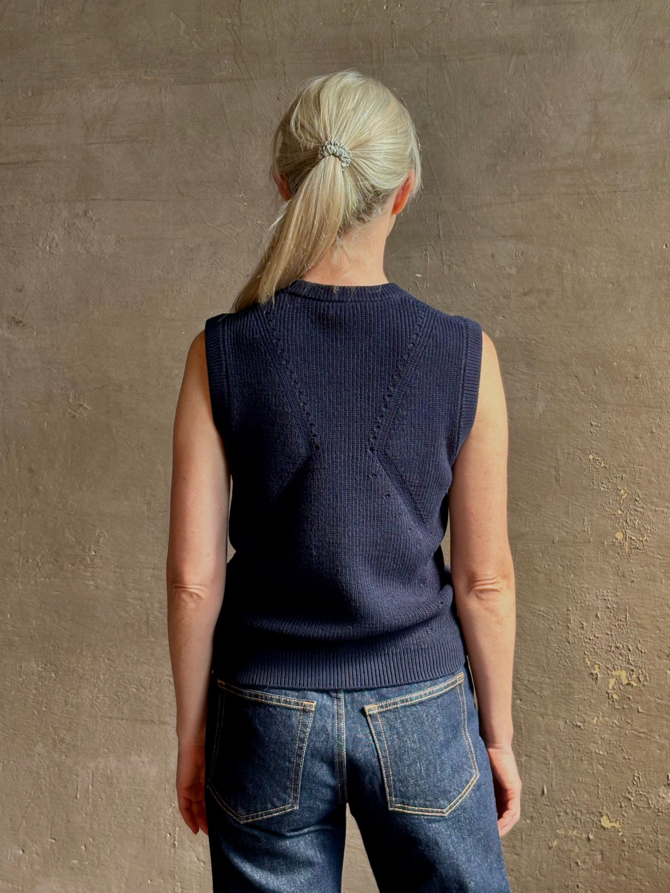 Mature woman wearing designer Margot sleeveless Knit Top from Ulla Johnson rendered in a rich midnight blue and knitted from 100% cotton with refined design details and a crew neckline for everyday sophistication