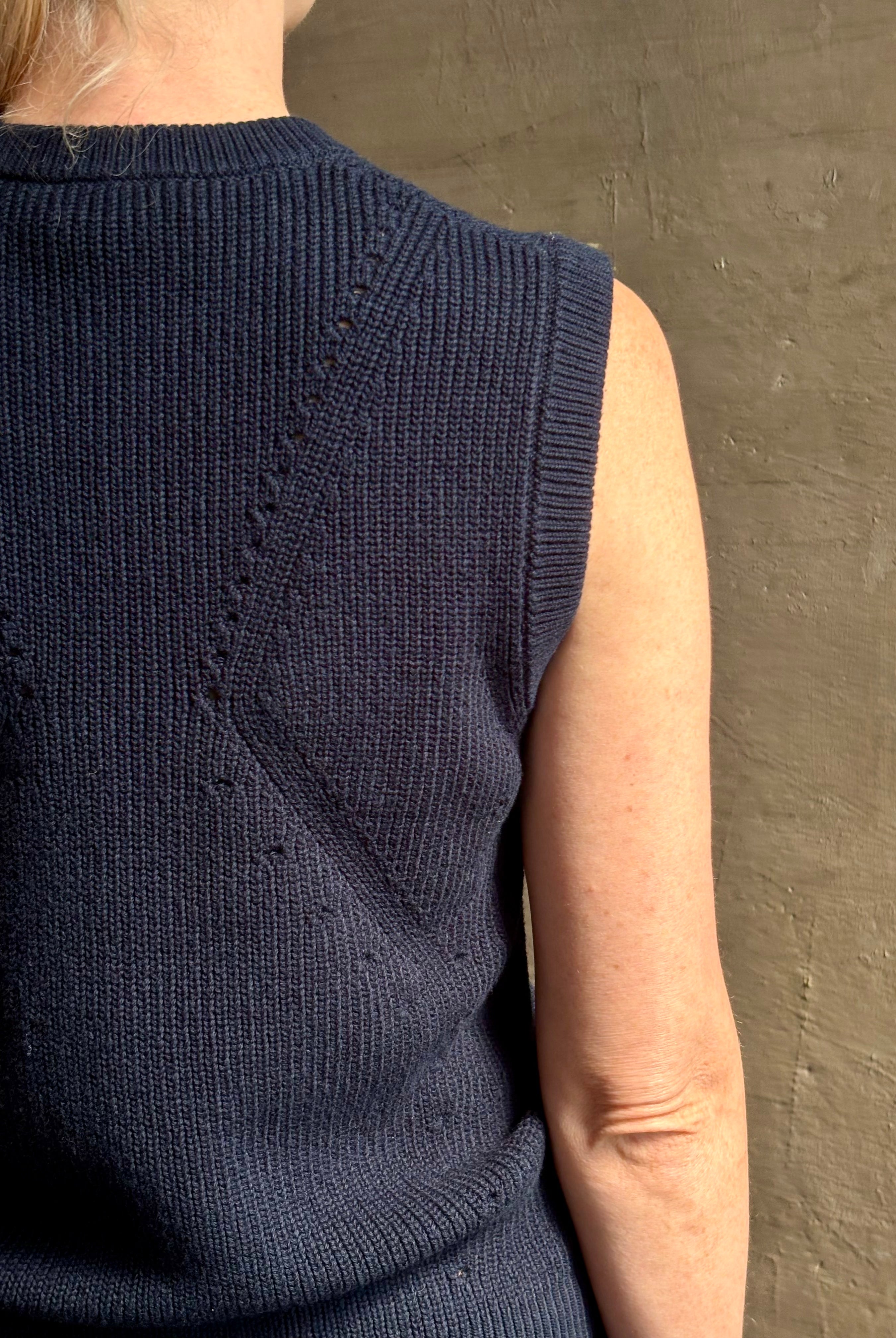 Mature woman wearing designer Margot sleeveless Knit Top from Ulla Johnson rendered in a rich midnight blue and knitted from 100% cotton with refined design details and a crew neckline for everyday sophistication