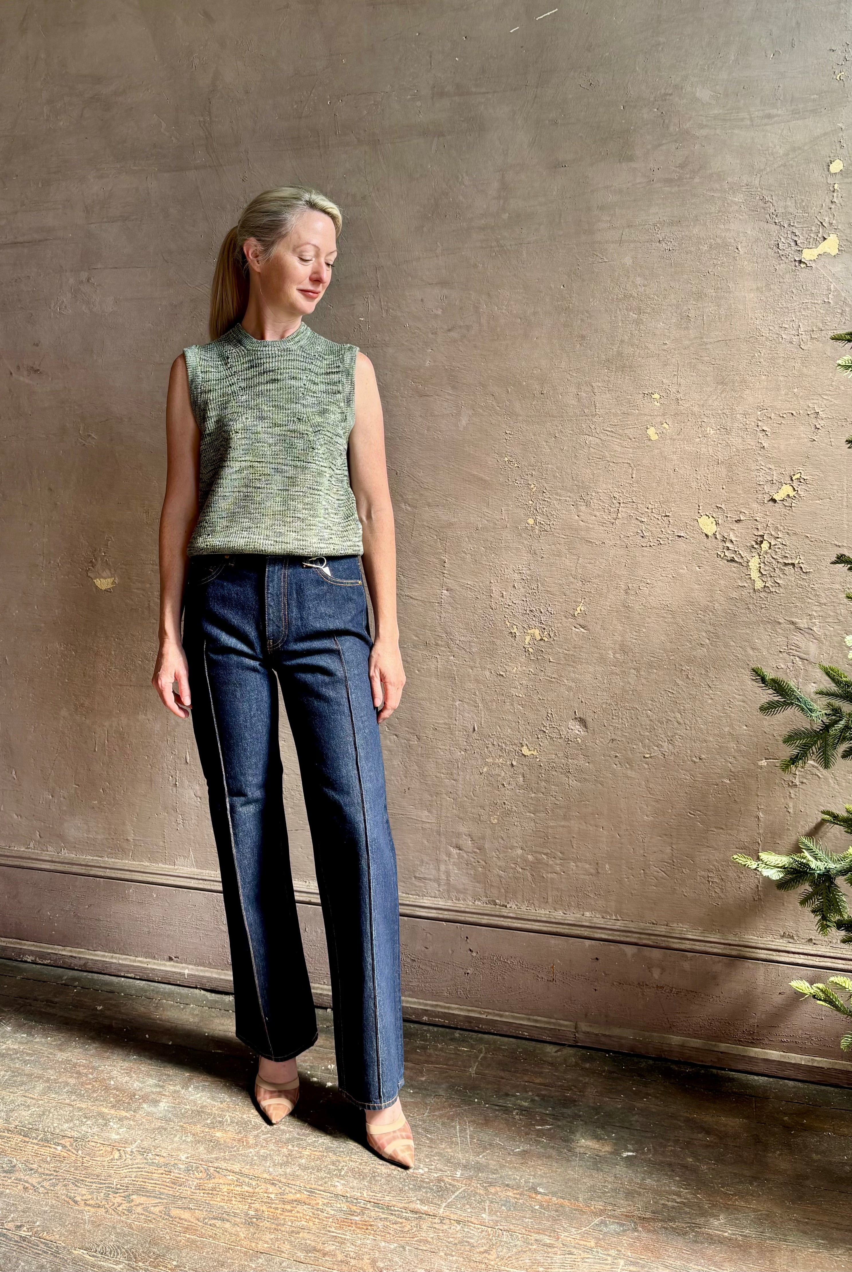 Mature model wearing Margot sleeveless Knit Top from Ulla Johnson rendered in a two tone heathered green and crafted from 100% cotton wth a crew neck and contrasting coral band at bottom