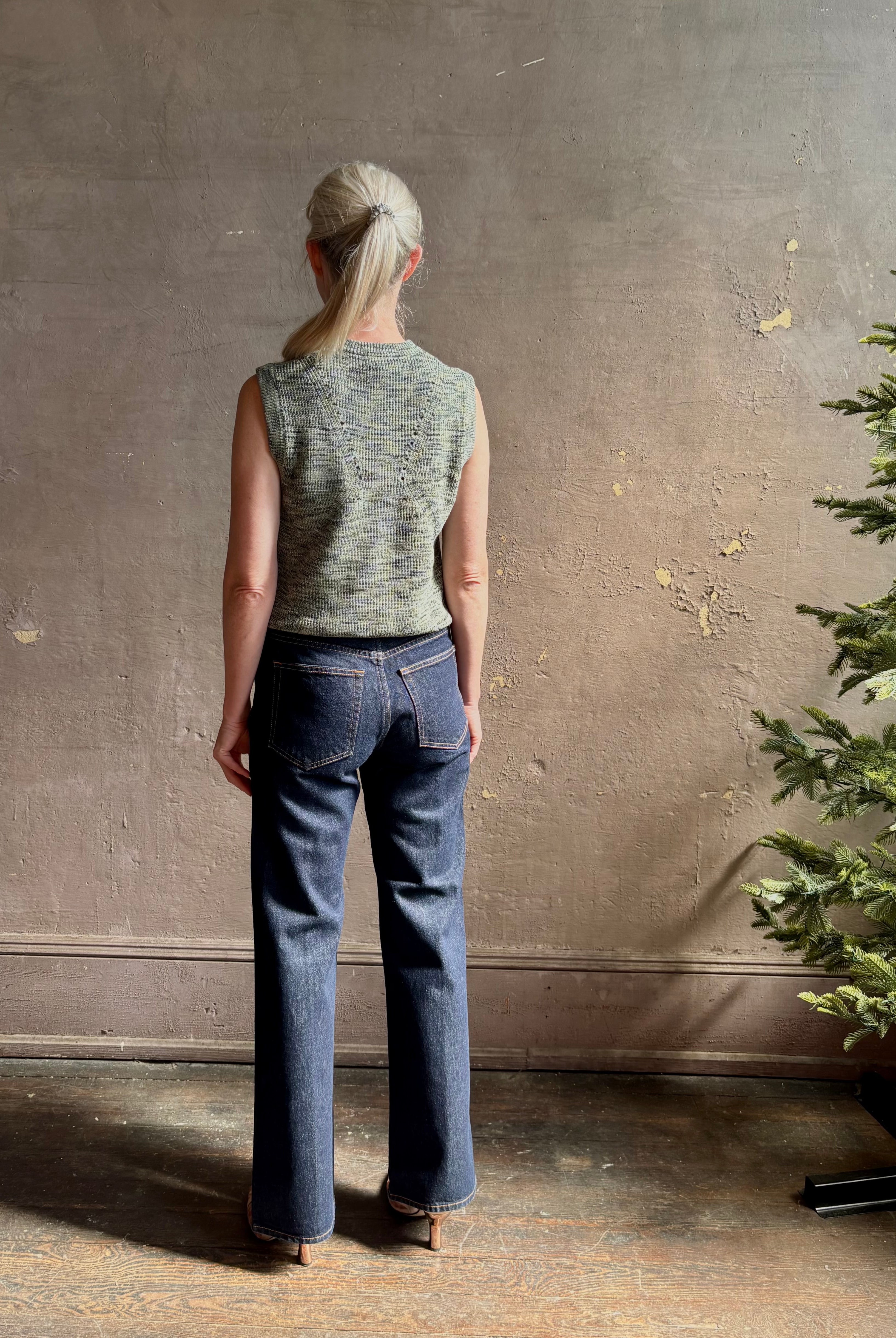 Mature model wearing Margot sleeveless Knit Top from Ulla Johnson rendered in a two tone heathered green and crafted from 100% cotton wth a crew neck and contrasting coral band at bottom