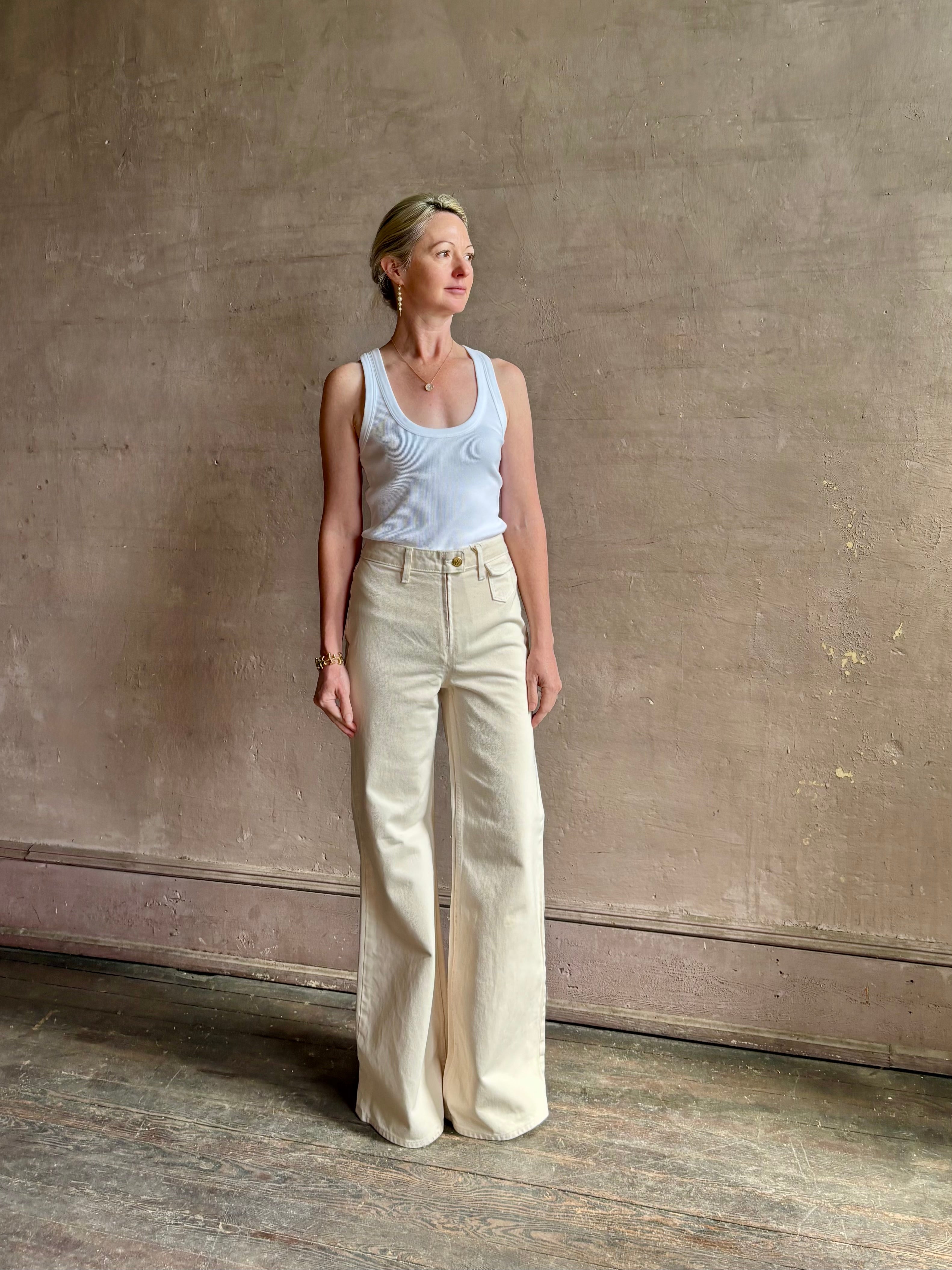 Woman wearing women's luxury designer denim by Ulla Johnson Odelia Jean handcrafted from 100% cotton in Los Angeles California with a high-rise and elegant slimmer wide leg