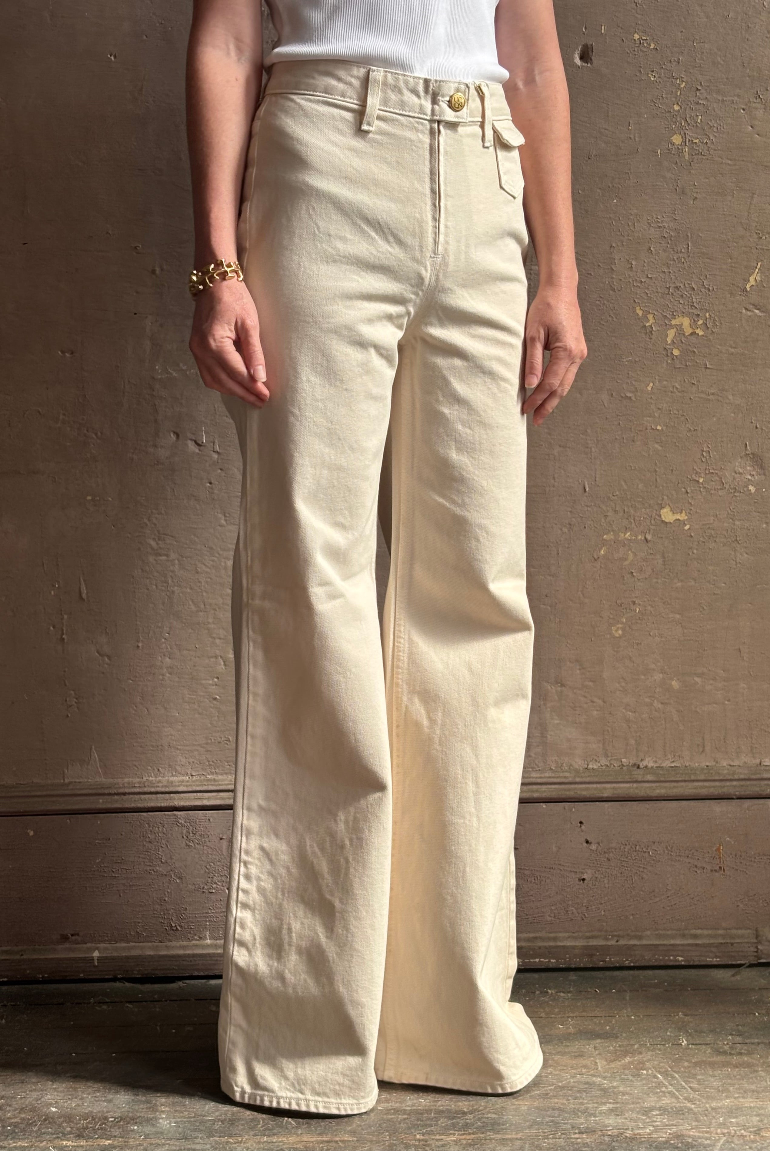 Woman wearing women's luxury designer denim by Ulla Johnson Odelia Jean handcrafted from 100% cotton in Los Angeles California with a high-rise and elegant slimmer wide leg