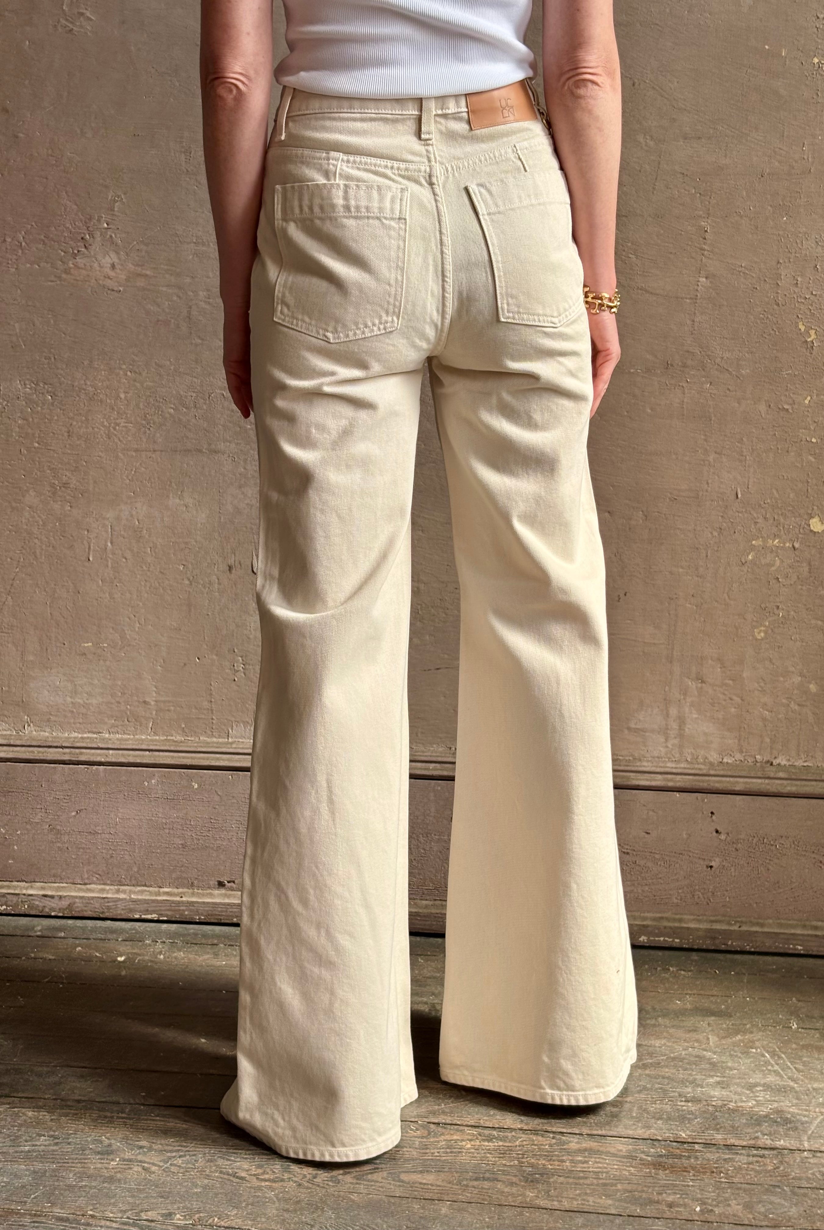 Woman wearing women's luxury designer denim by Ulla Johnson Odelia Jean handcrafted from 100% cotton in Los Angeles California with a high-rise and elegant slimmer wide leg