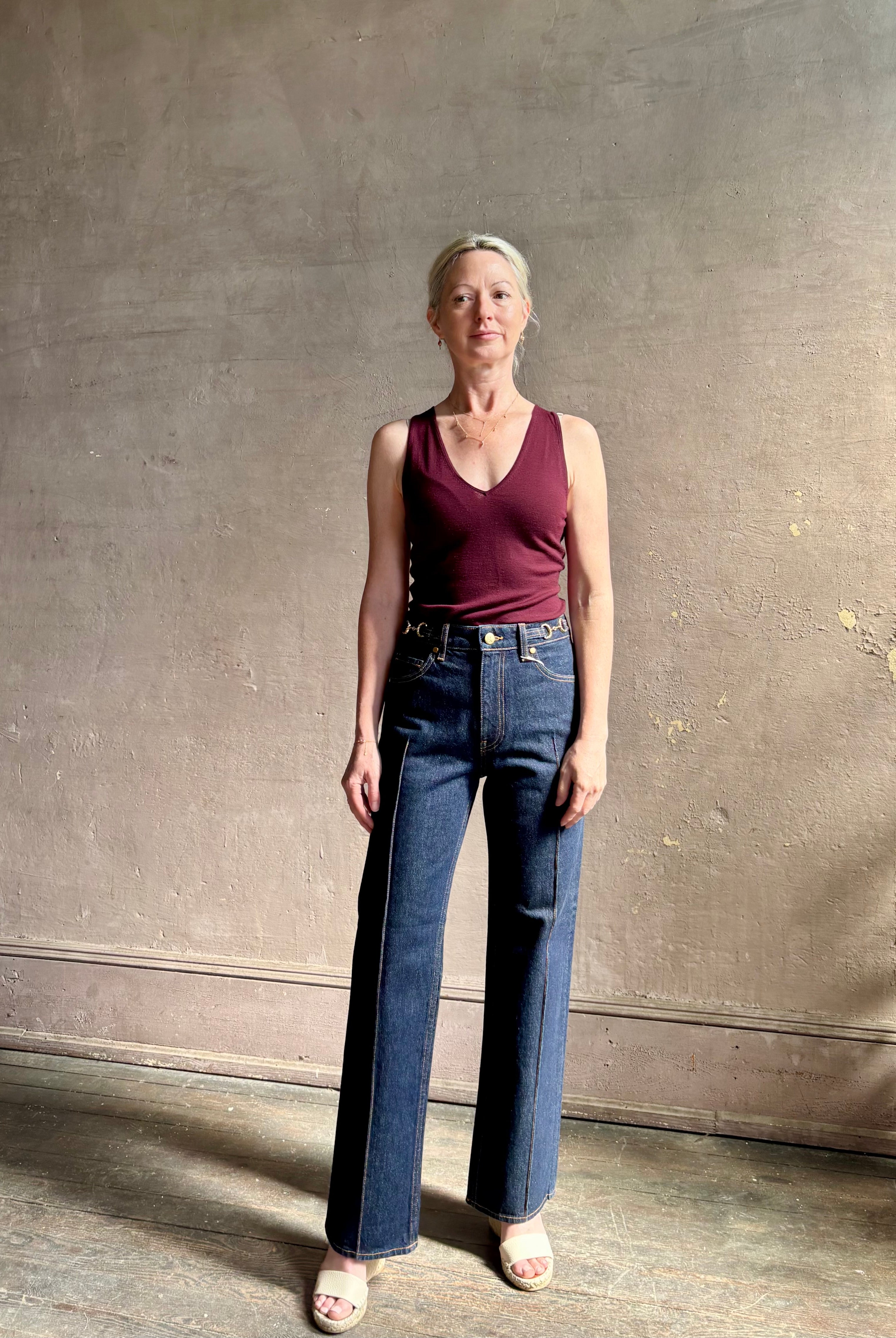 Woman wearing ULLA JOHNSON Agatha Straight Leg Pintuck Rigid Denim jean in Tigris wash with horsebit detail