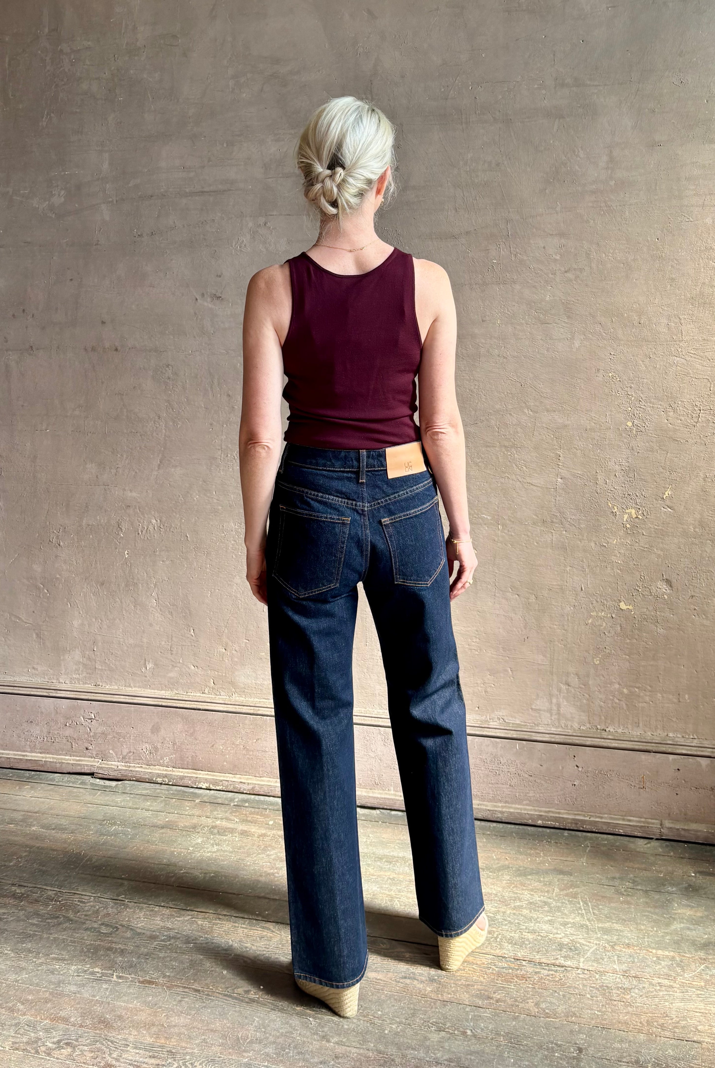 Woman wearing ULLA JOHNSON Agatha Straight Leg Pintuck Rigid Denim jean in Tigris wash with horsebit detail
