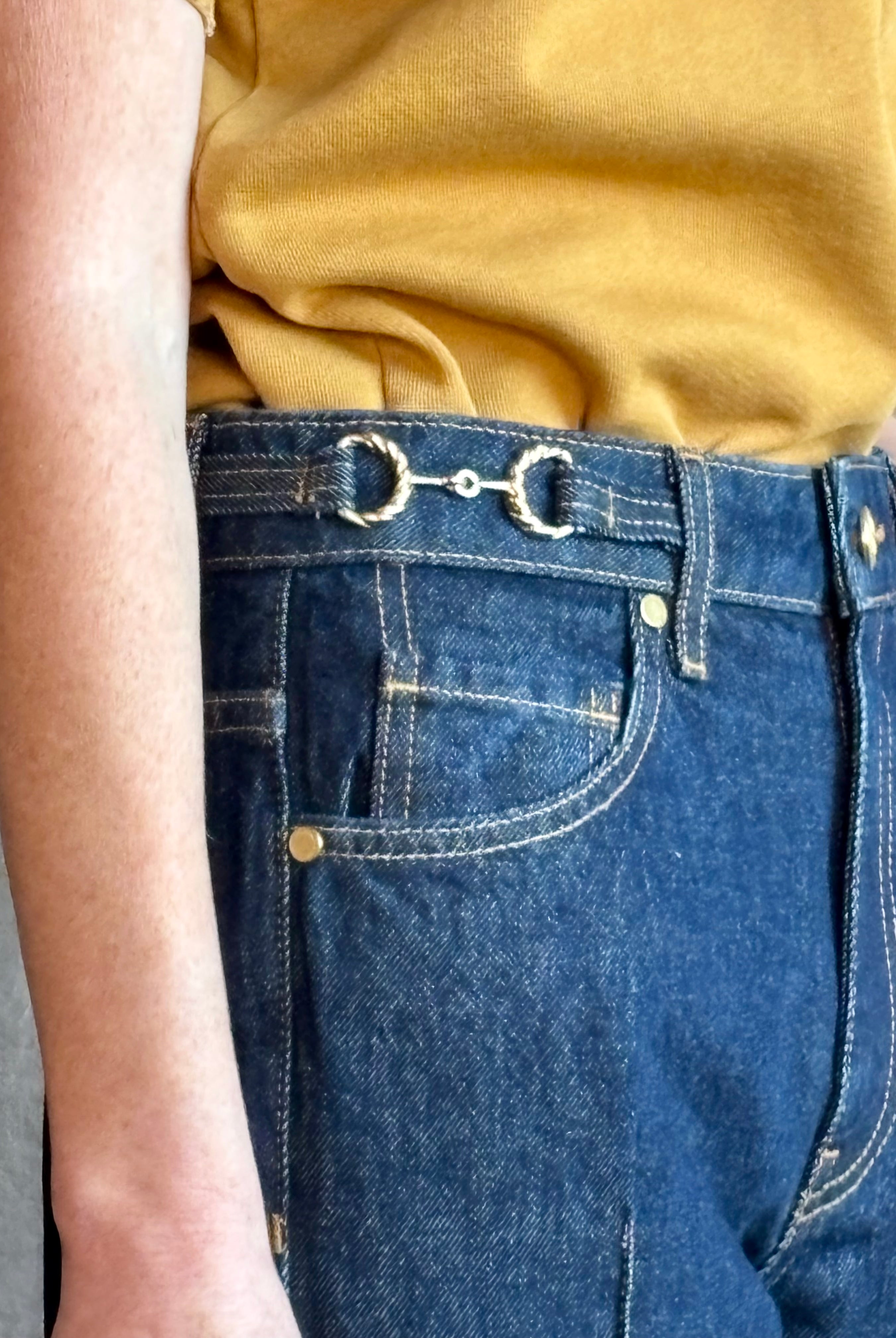 Woman wearing ULLA JOHNSON handmade Agatha Straight Leg Pintuck Rigid Denim jean in Tigris wash with horsebit detail