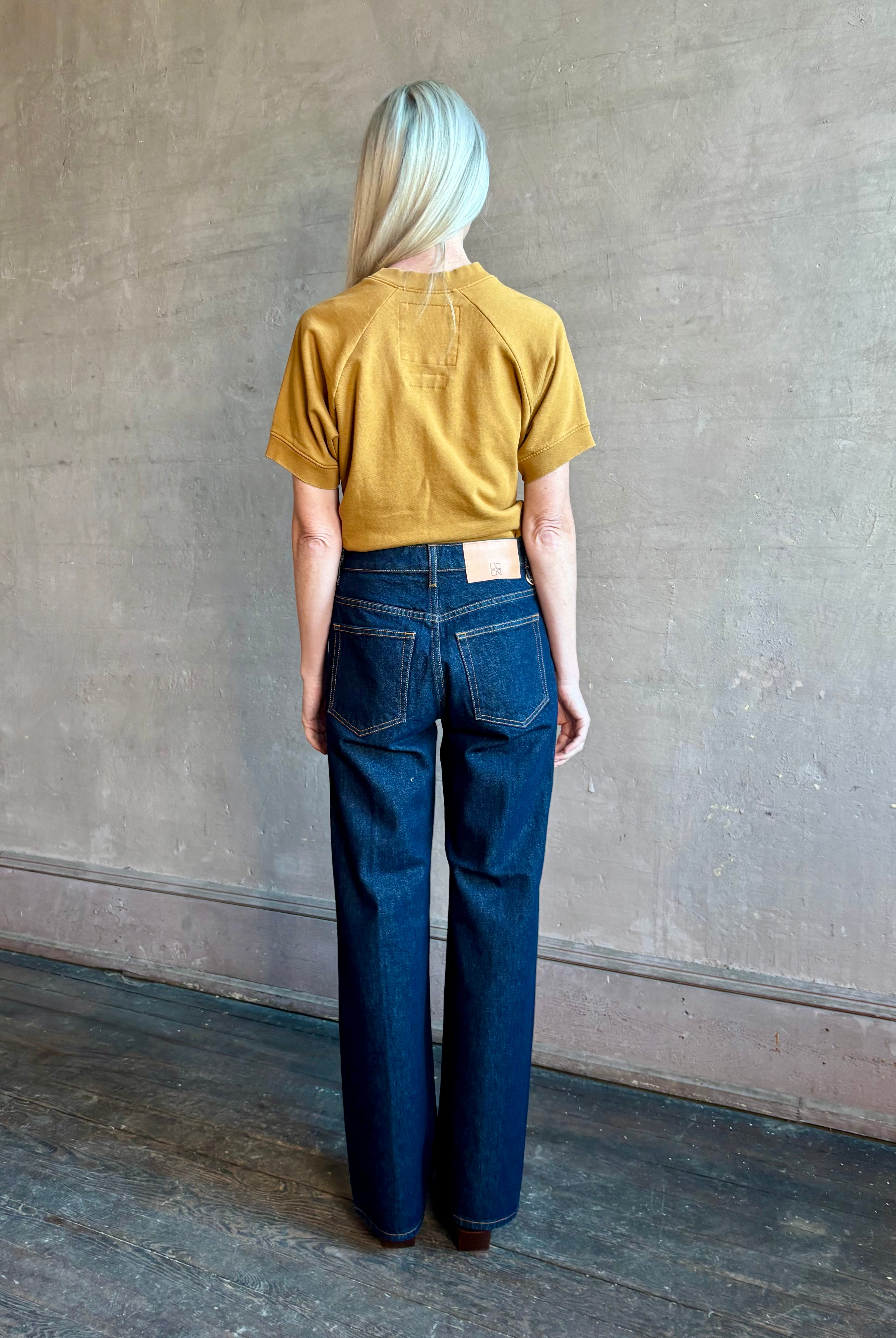 Woman wearing ULLA JOHNSON handmade Agatha Straight Leg Pintuck Rigid Denim jean in Tigris wash with horsebit detail