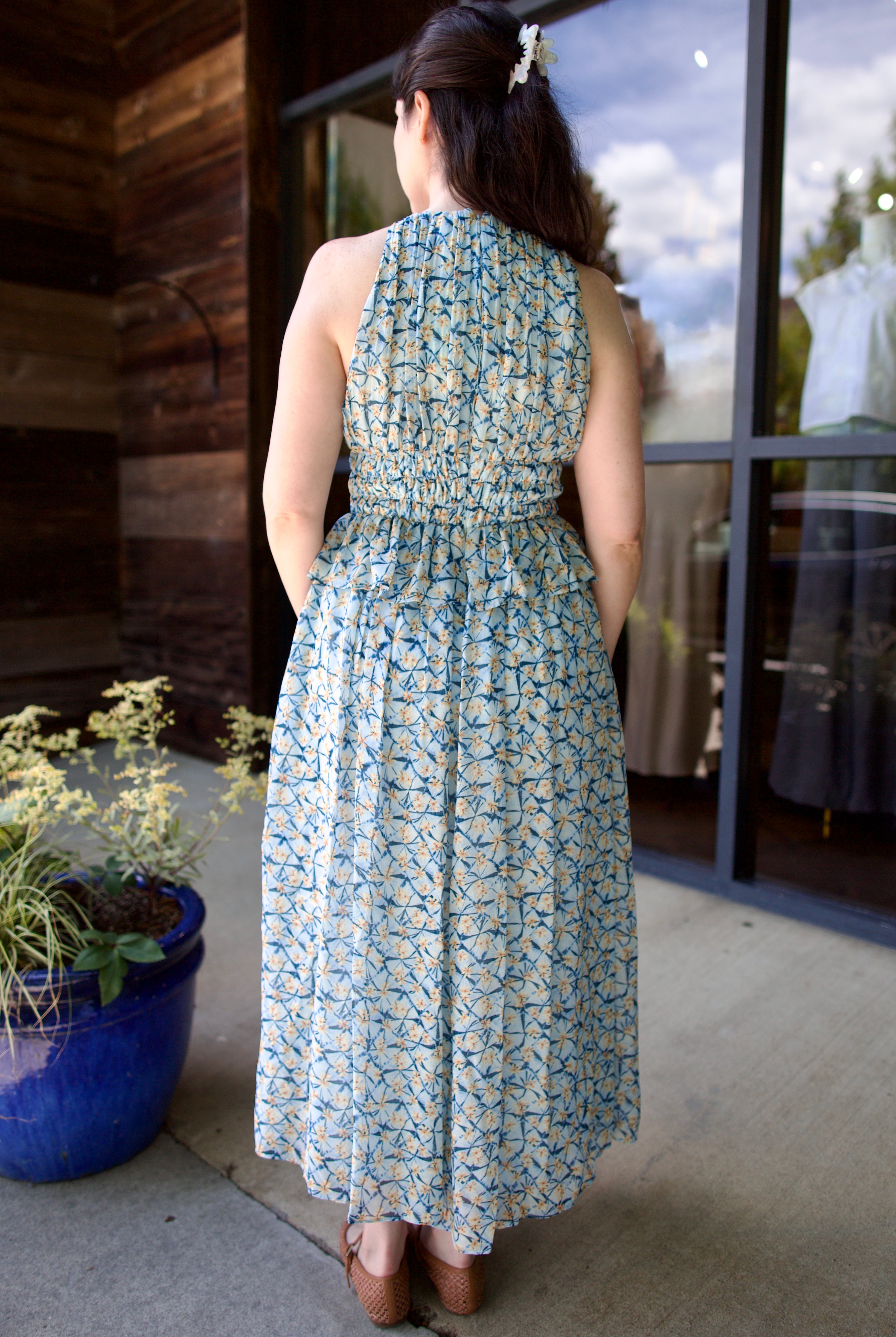 Image of model wearing designer Ulla Johnson Adeline dress with flattering peplum and pin-tucking at waistline