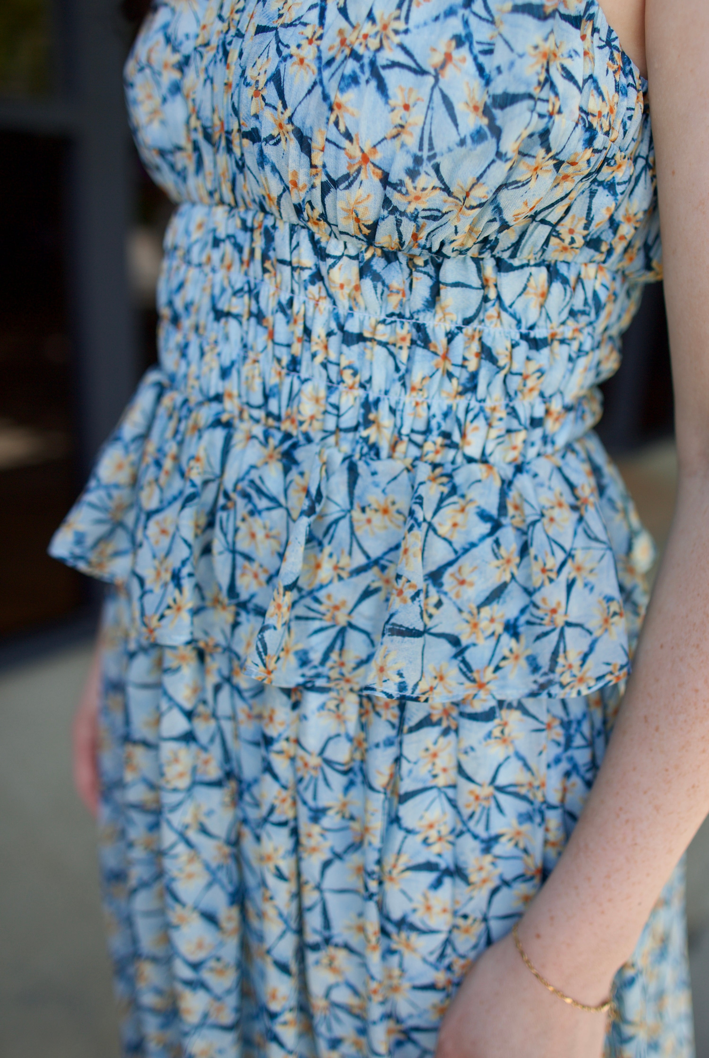 Detail image of model wearing designer Ulla Johnson Adeline dress with flattering peplum and pin-tucking at waistline