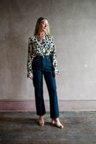 Mature model wearing designer denim jean by Ulla Johnson with a  high rise straight, cropped leg with contrast stitching in dark wash.