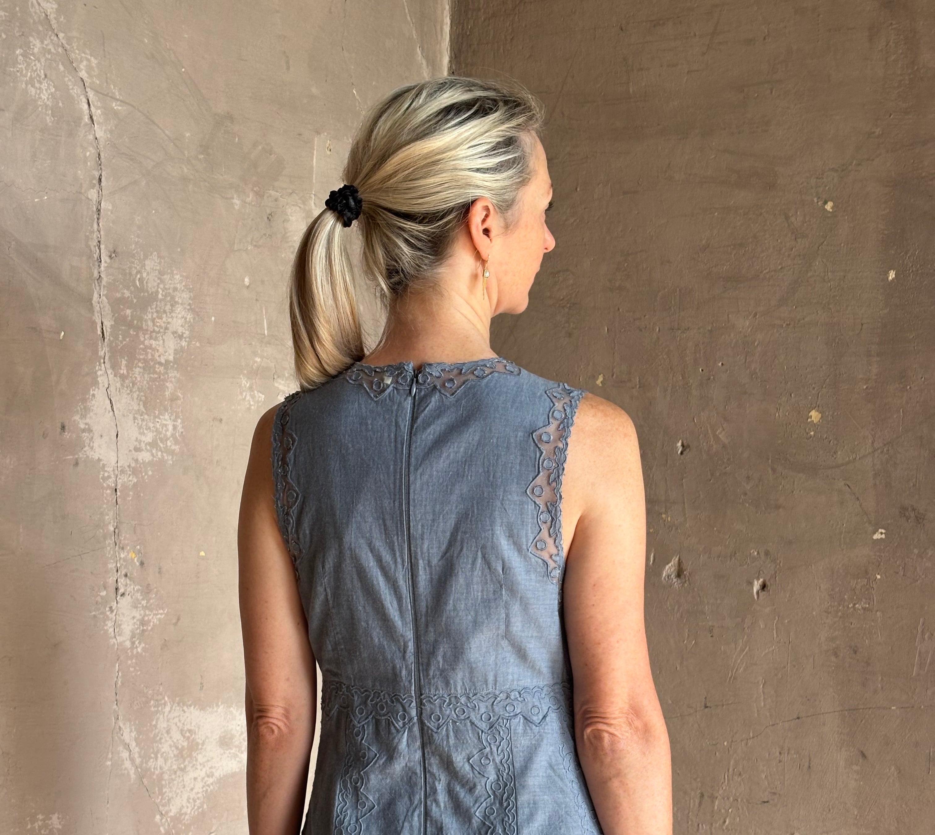 Woman wearing classic Ulla Johnson Anela midi chambray dress delicate lace details sleeveless fit and flare