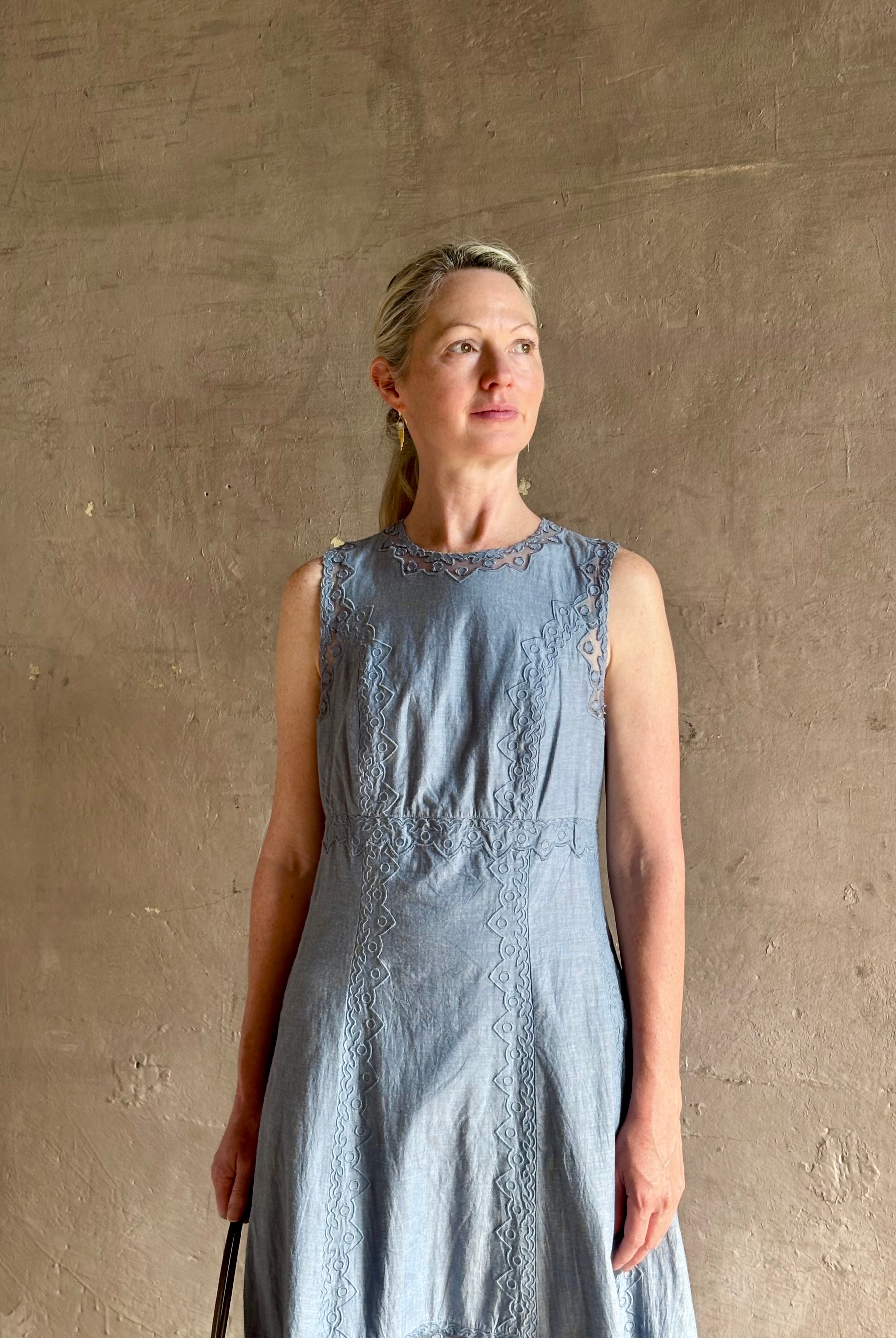 Woman wearing classic Ulla Johnson Anela midi chambray dress delicate lace details sleeveless fit and flare