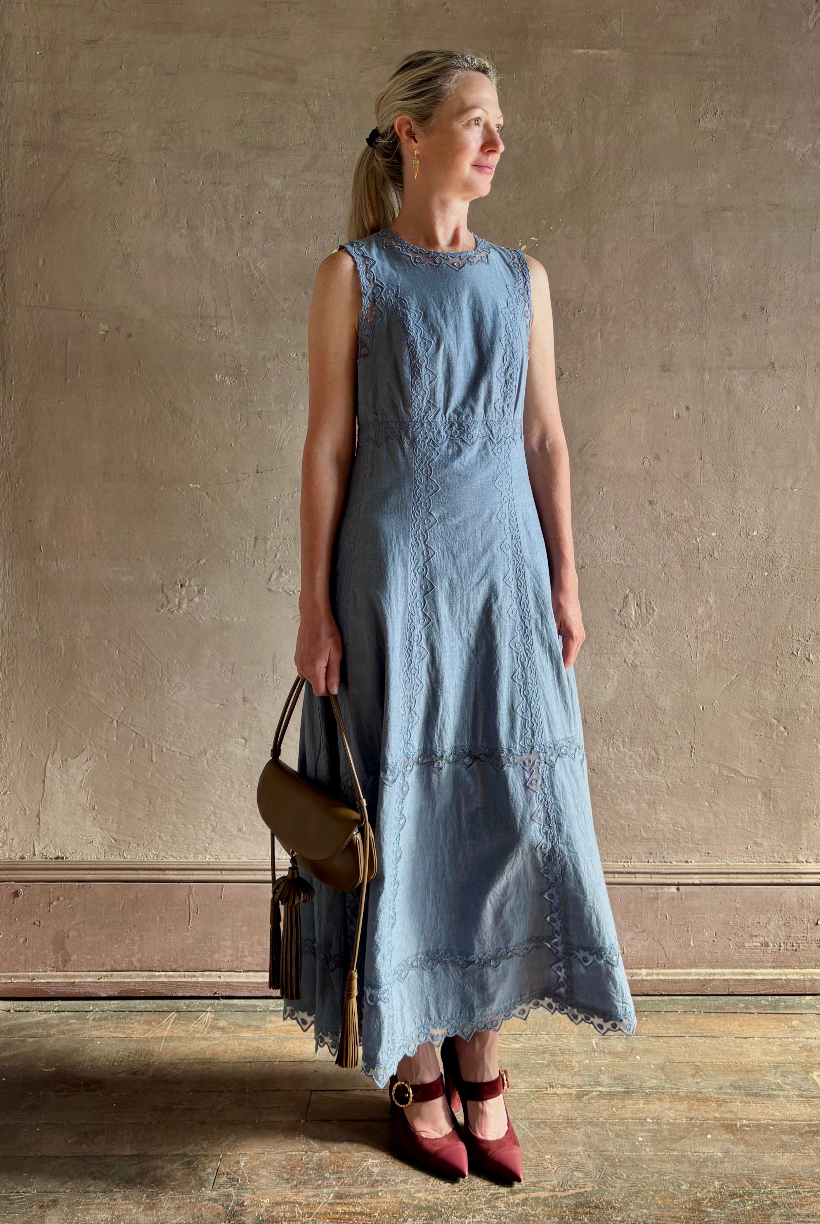 Woman wearing classic Ulla Johnson Anela midi chambray dress delicate lace details sleeveless fit and flare