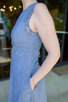 Detail image showing Ulla Johnson Anela midi dress in chambray with delicate lace details outlining arm as well as hidden seam pockets