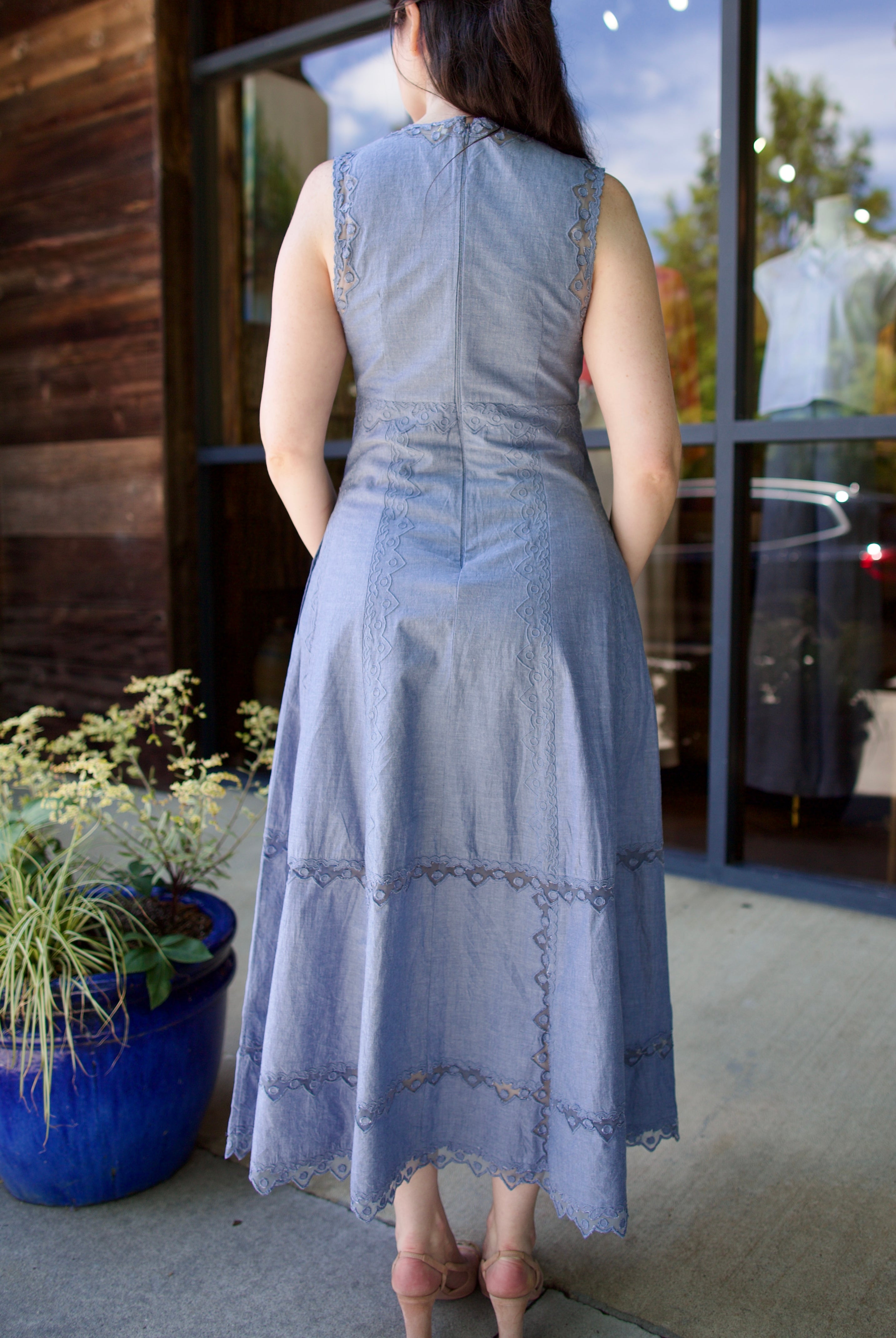 Image of model showing back details of the Ulla Johnson Anela midi dress in chambray with delicate lace details and hidden zipper