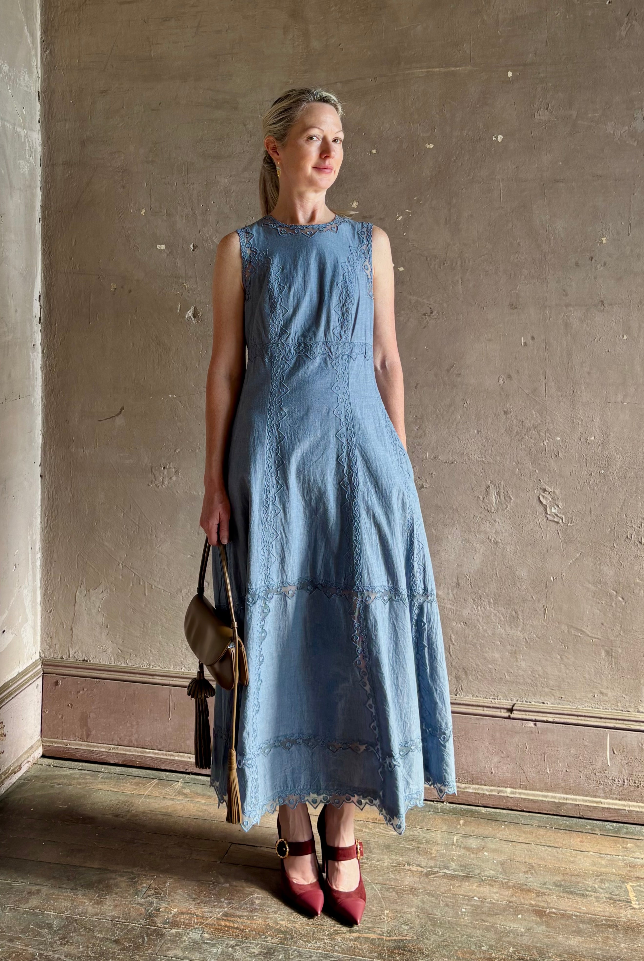 Woman wearing classic Ulla Johnson Anela midi chambray dress delicate lace details sleeveless fit and flare