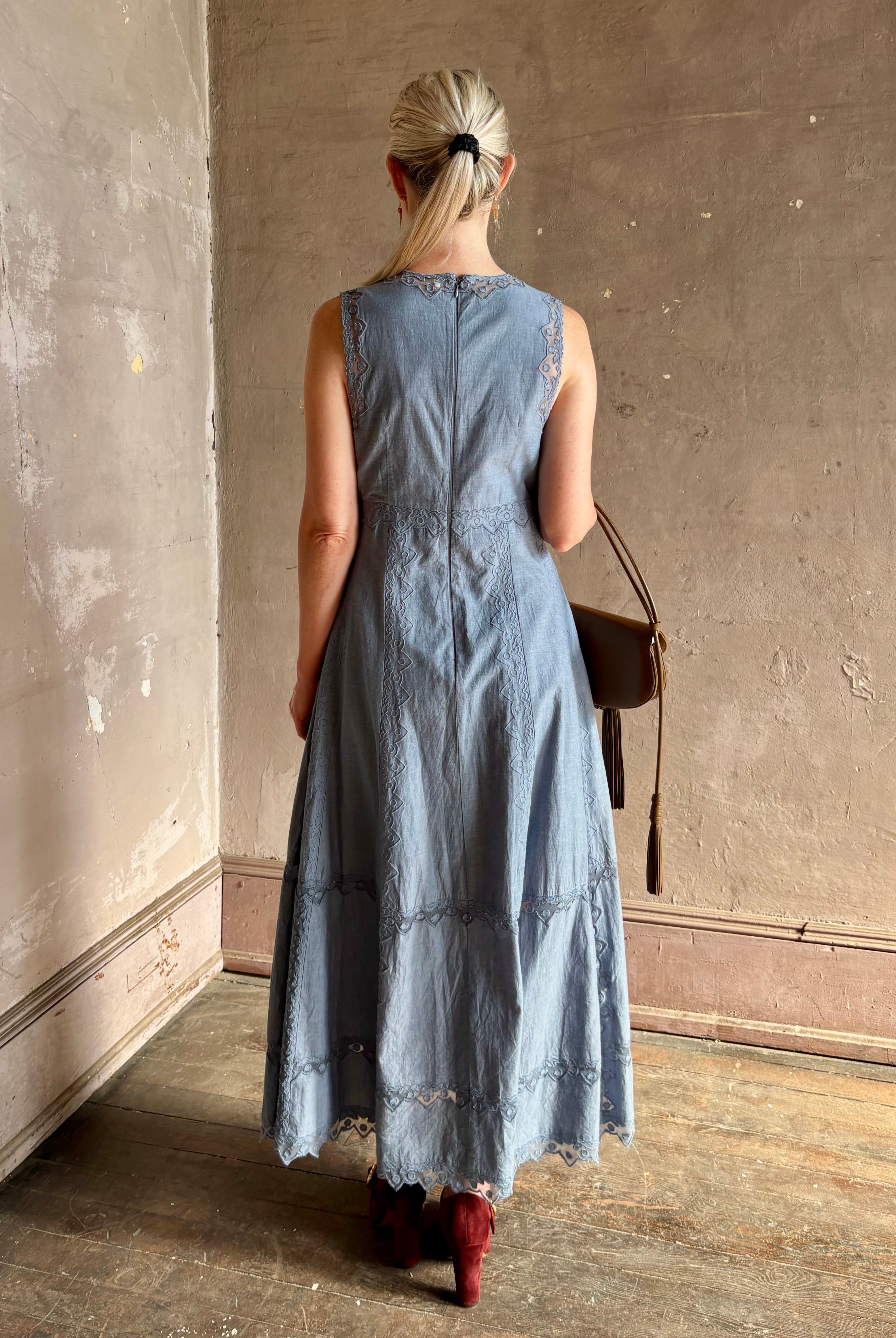 Woman wearing classic Ulla Johnson Anela midi chambray dress delicate lace details sleeveless fit and flare